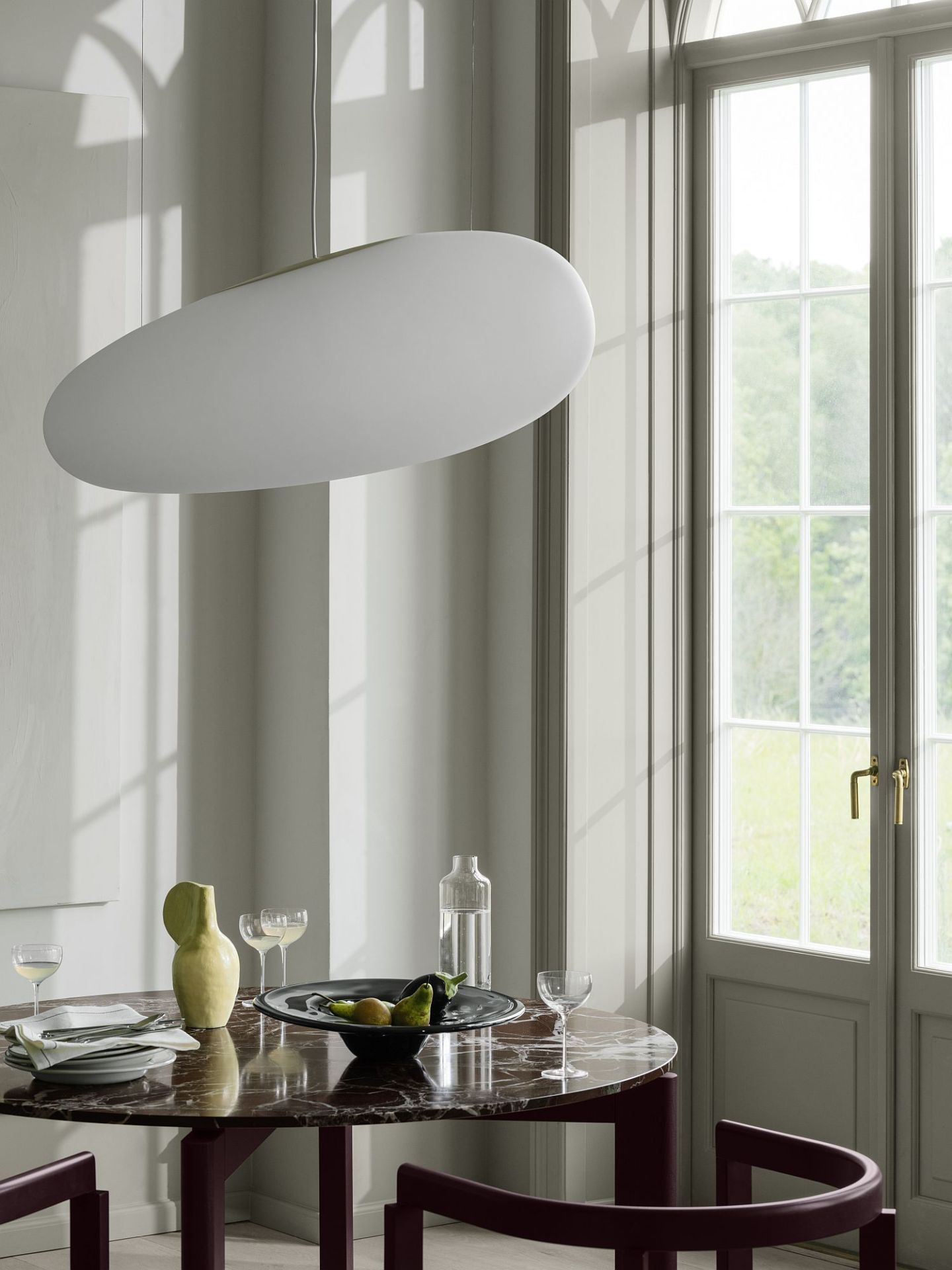 After Dinning Esstisch von Fritz Hansen mit Marmorplatte und passenden Stühlen unter einer modernen Pendelleuchte.