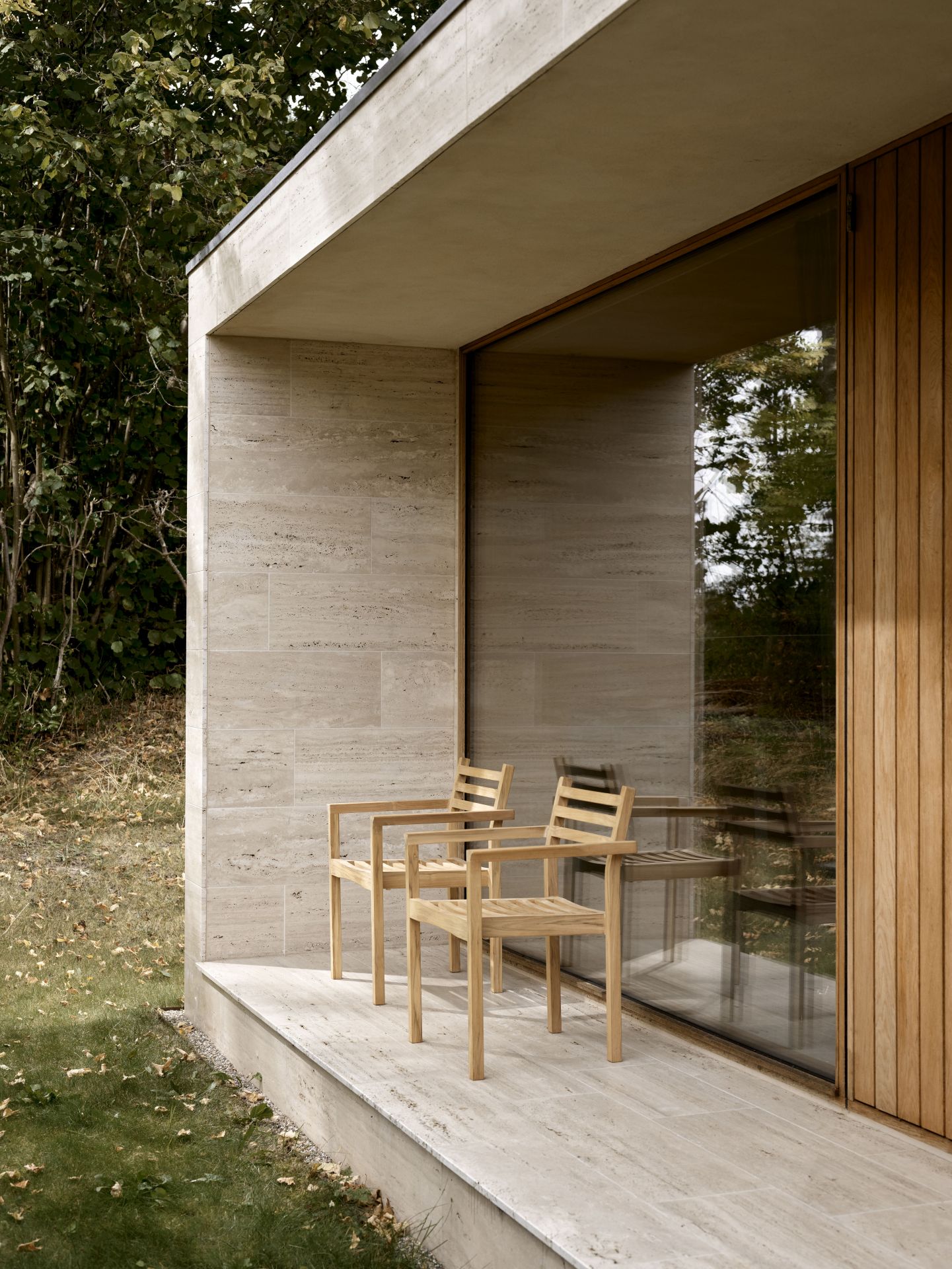 Zwei AH502 Teak Armlehnstühle von Carl Hansen & Søn auf einer Terrasse im Freien.