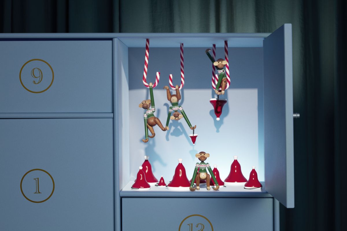 Kay Bojesen Christmas Jumper Affe 2025 Mini, grüne Holzfigur in einem Adventskalender mit Zuckerstangen und Weihnachtsmützen.