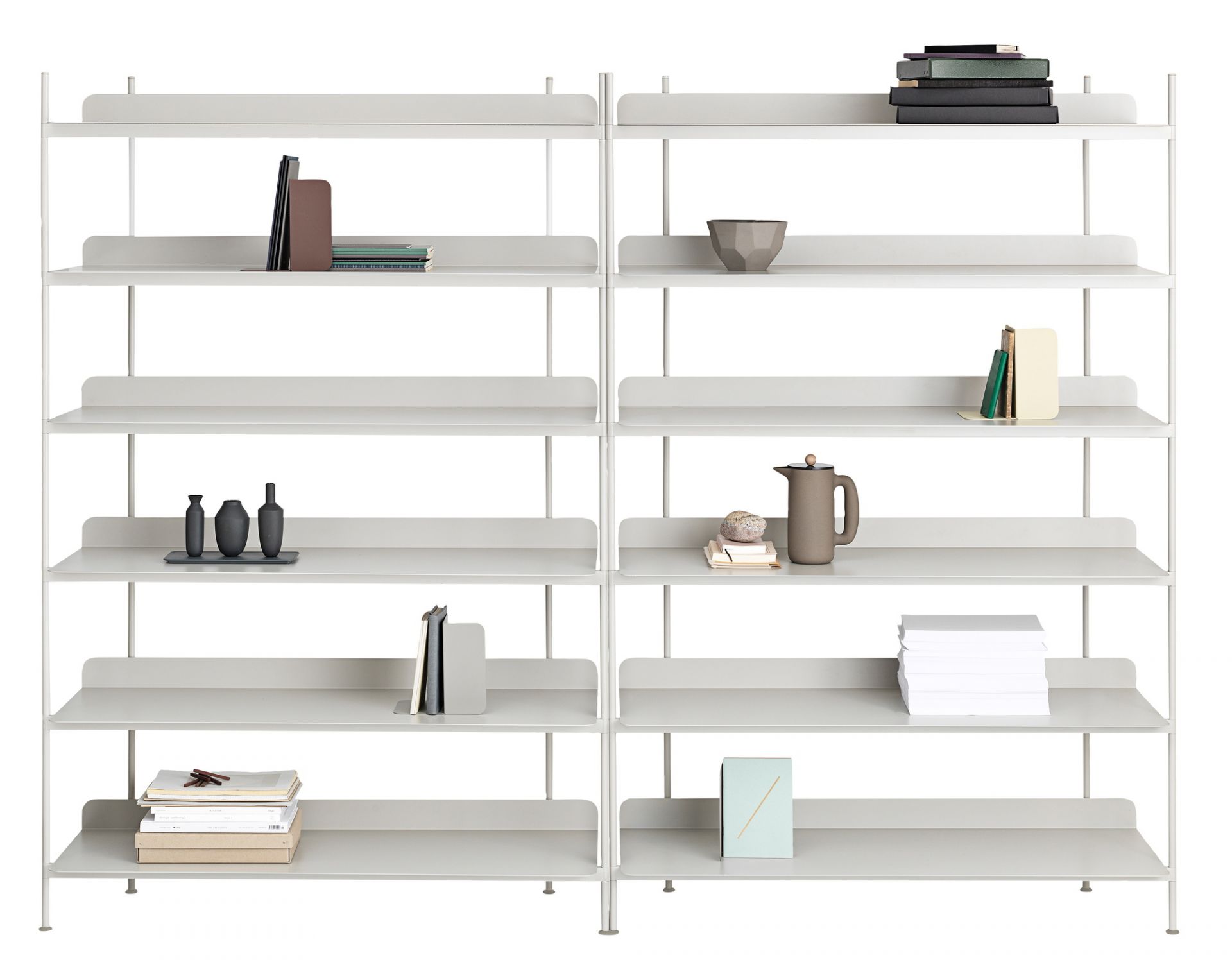 Muuto Compile Regalsystem in hellgrau mit Büchern, Vasen und Deko-Objekten auf den Regalen.