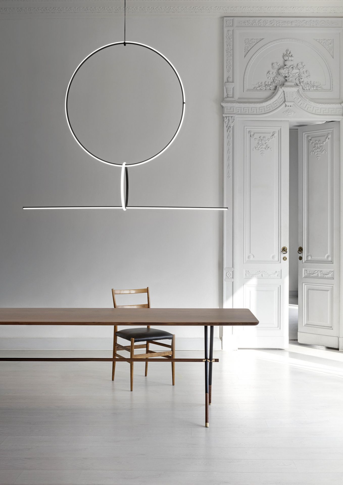 Moderne Flos Arrangements Pendelleuchte über Esstisch mit Stuhl in stilvollem, hellem Interieur. Design Hängeleuchte.