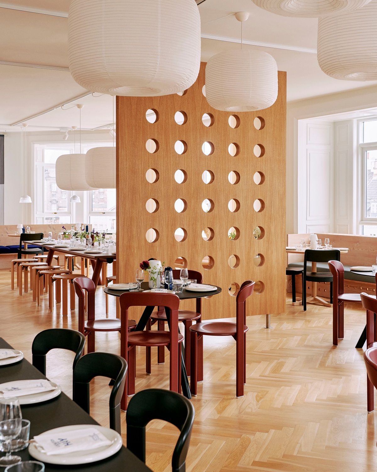 Helle Innenaufnahme eines Restaurants mit mehreren Hay Paper Shade-Donut Lampenschirmen in klassischem Weiß.