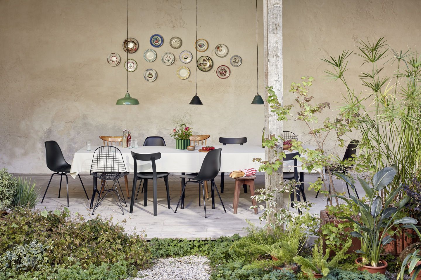 Esstisch mit verschiedenen Stühlen, darunter ein schwarzer Eames Fiberglass Chair DSX Stuhl von Vitra.
