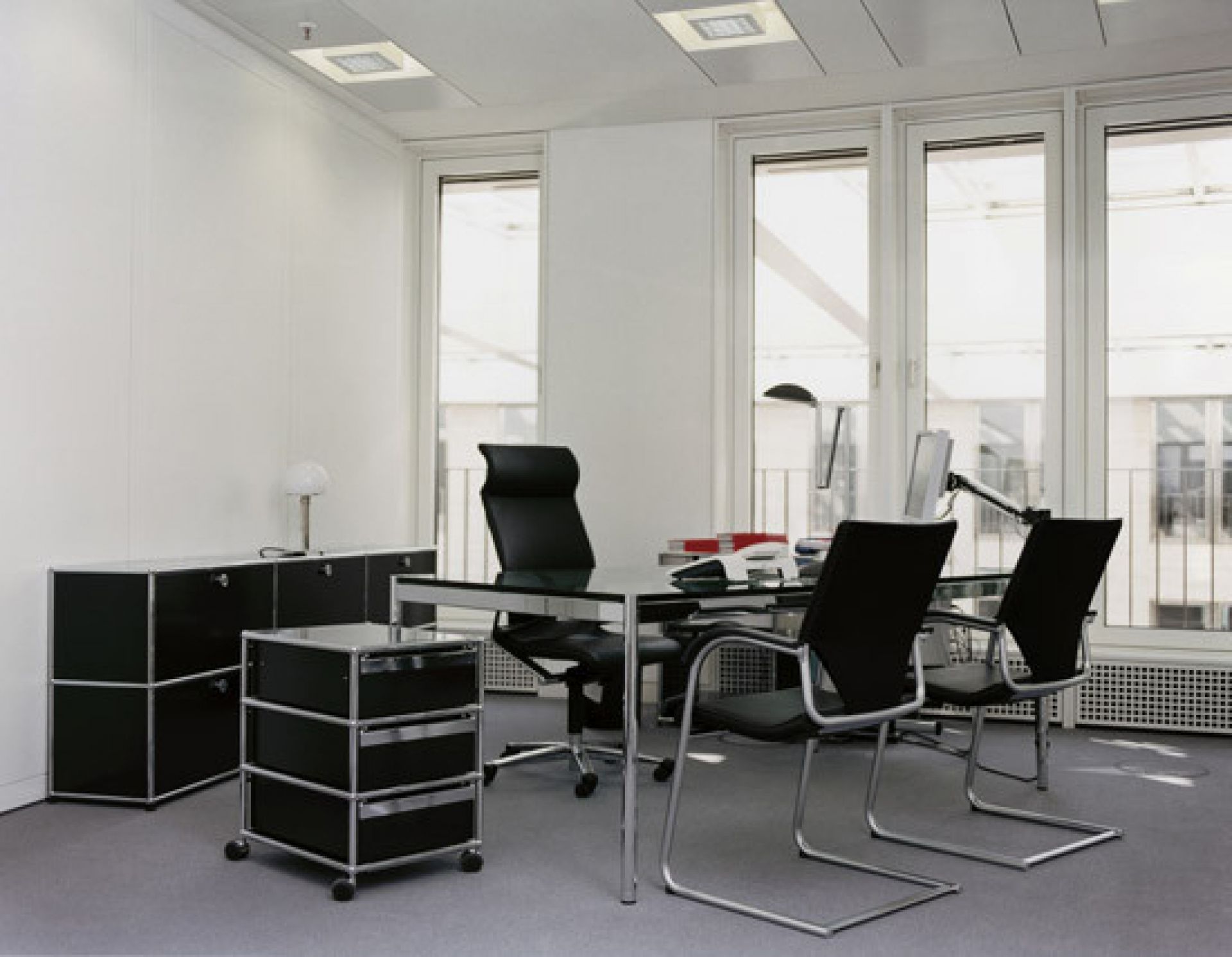 Schwarzes USM Sideboard mit Lederauflage in einer Büroecke, hochwertige Möbel für stilvolles Design.