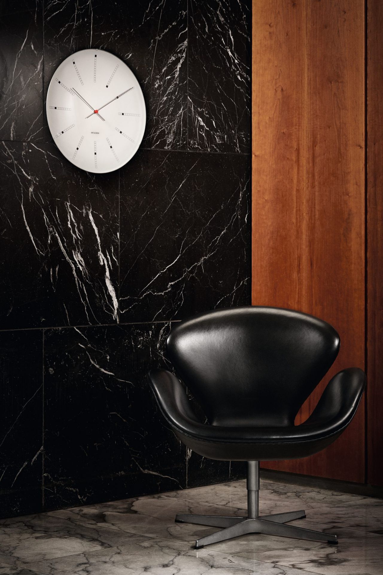 Bankers Wanduhr von Rosendahl Timepieces, 21 cm Durchmesser, an einer Marmorwand. Design-Klassiker für stilvolle Wohnräume.