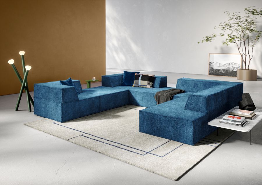 Blaues Trio Sofa mit vier Modulen und Eckanordnung links, moderne Wohnzimmer Einrichtung.