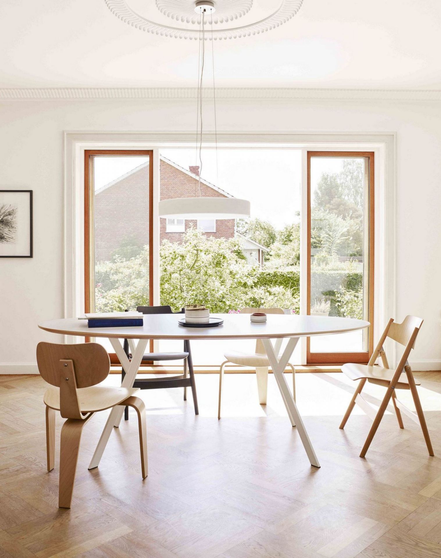Esszimmer mit ovalem Tisch und mehreren SE 42 Stühlen von Wilde+Spieth in hellem Holz.