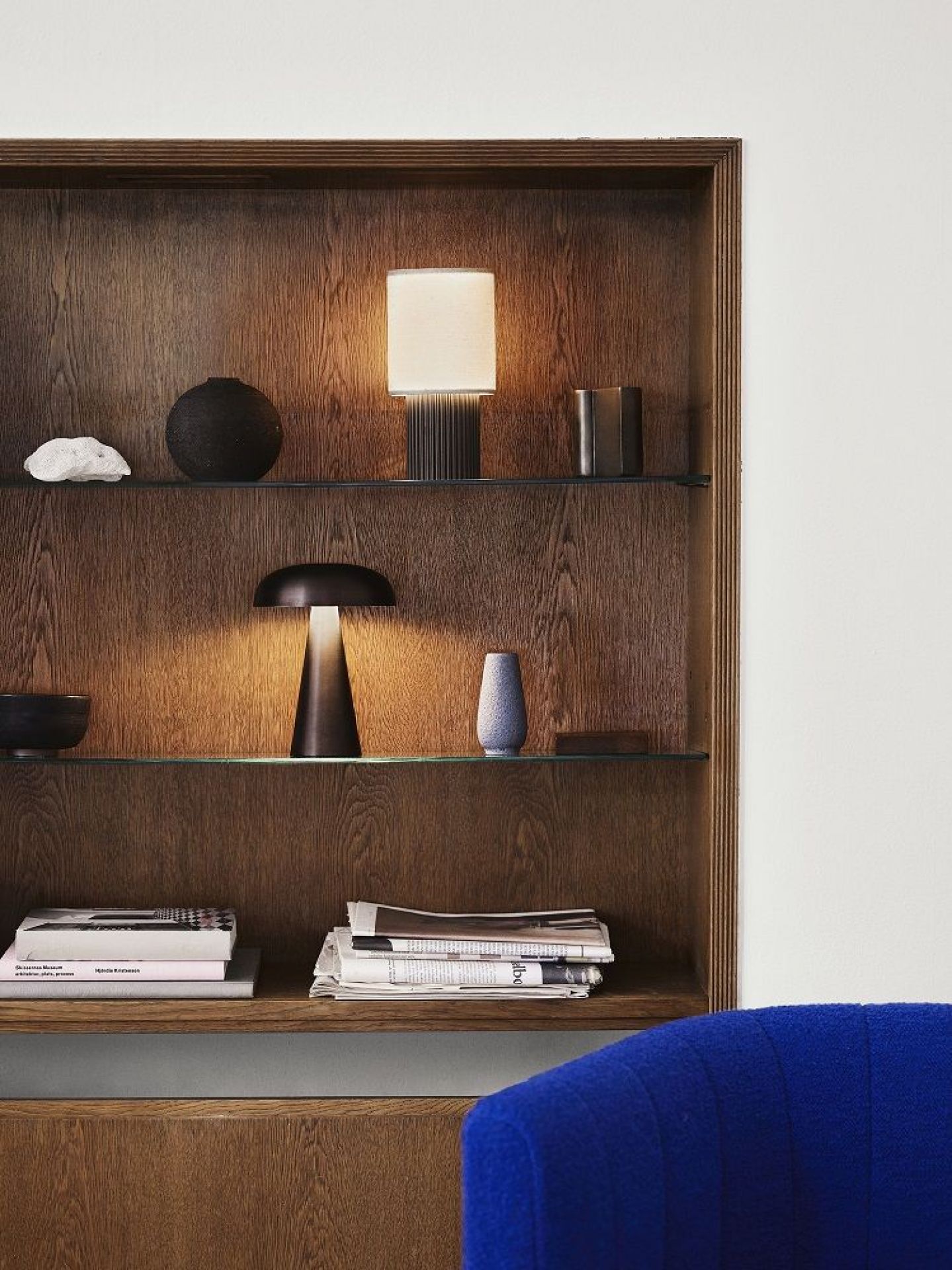 AndTradition Como SC53 Akkuleuchte in dunklem Holzregal, stimmungsvolles Licht, tragbare Tischleuchte mit USB.