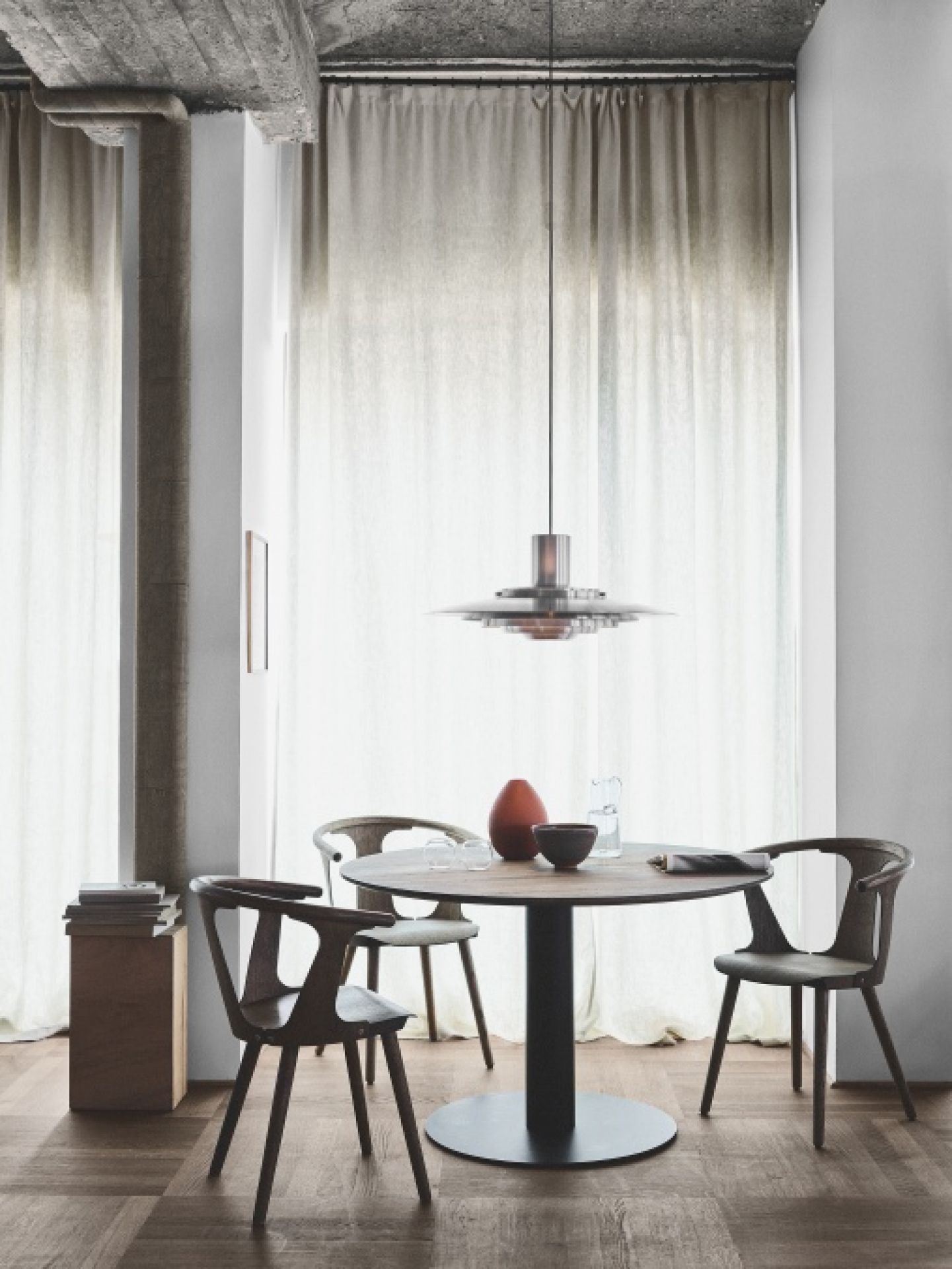 Esszimmer mit rundem Tisch und drei schwarzen In Between Stühlen SK1 von AndTradition.