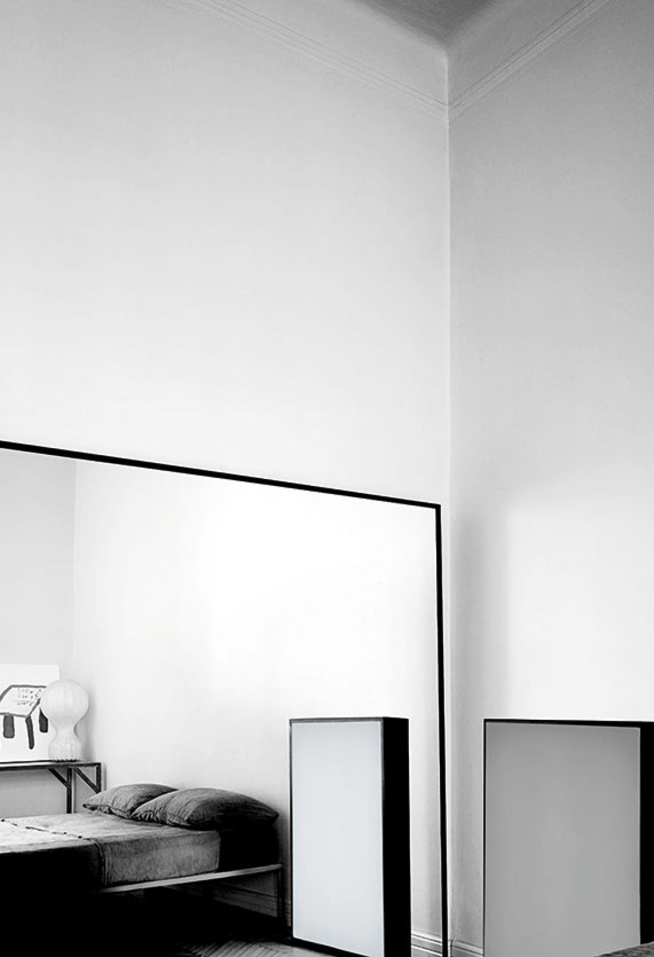 Schlafzimmer Interieur mit großem Spiegel, minimalistischem Bett und moderner Stehlampe in Schwarzweiß, für stilvolle Raumgestaltung.