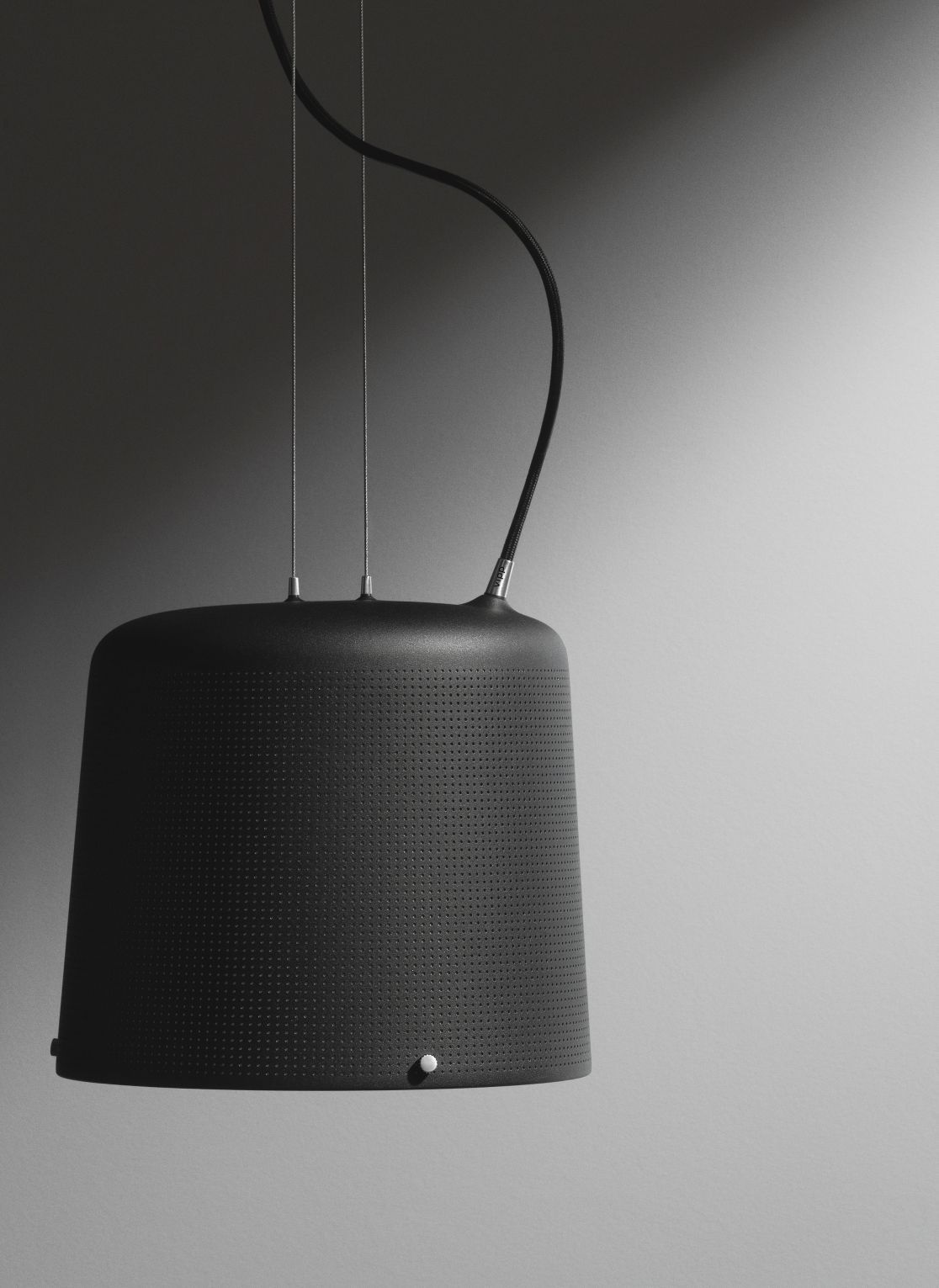 Nahaufnahme der Vipp Pendelleuchte, modernes Design mit perforierter Oberfläche und schwarzem Kabel.