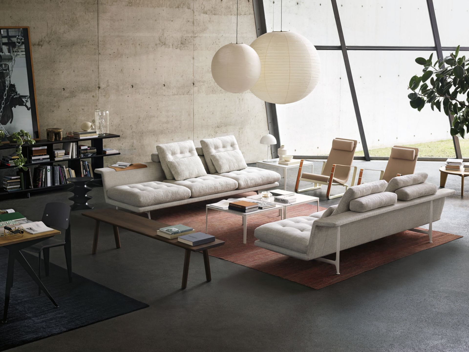 Moderne Wohnzimmer-Szene mit zwei Akari Pendelleuchten von Vitra, die über einer Sofagarnitur hängen.