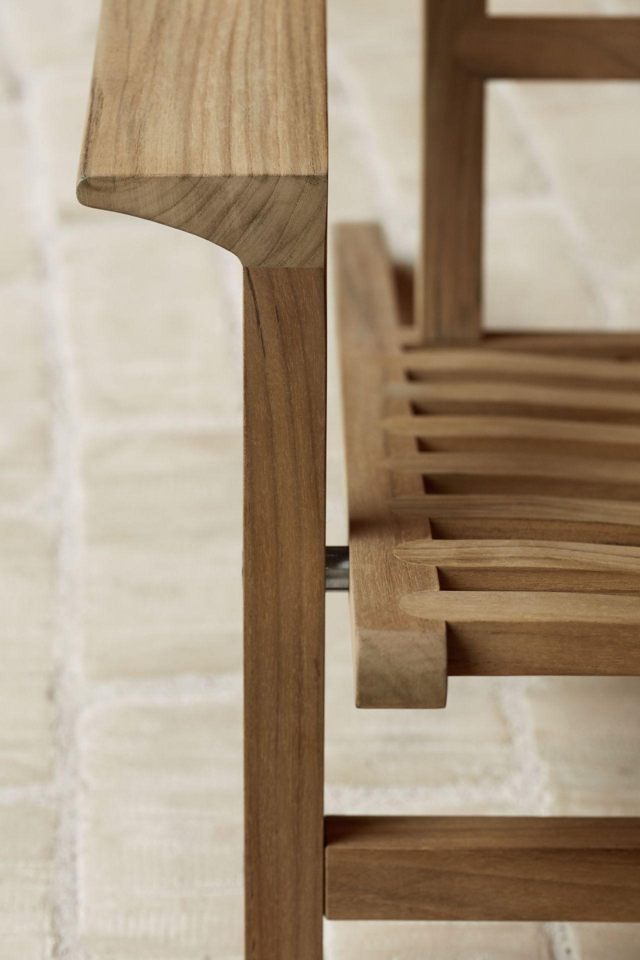 Detailaufnahme des AH603 Sonnenstuhl Teak von Carl Hansen & Søn, Fokus auf Armlehne und Holzstruktur.