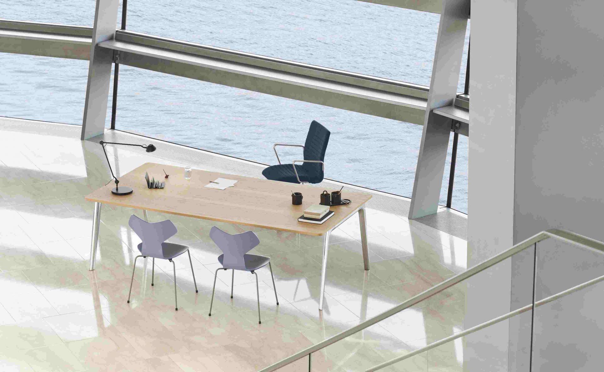 Büro mit Schreibtisch, Grand Prix Stühlen von Fritz Hansen und Bürostuhl vor Fenster mit Meerblick.