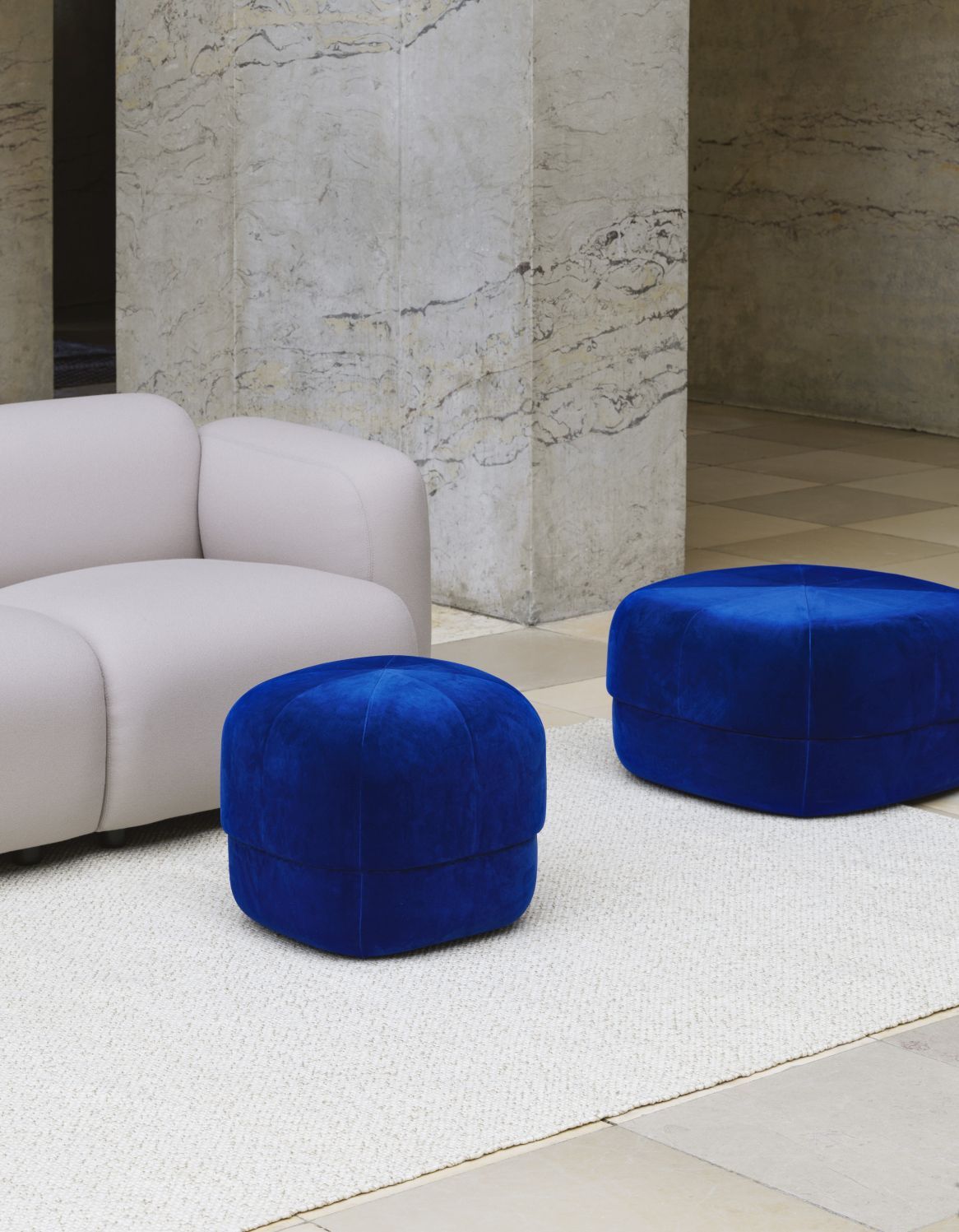 Zwei blaue Circus Pouf Hocker von Normann Copenhagen auf einem hellen Teppich.