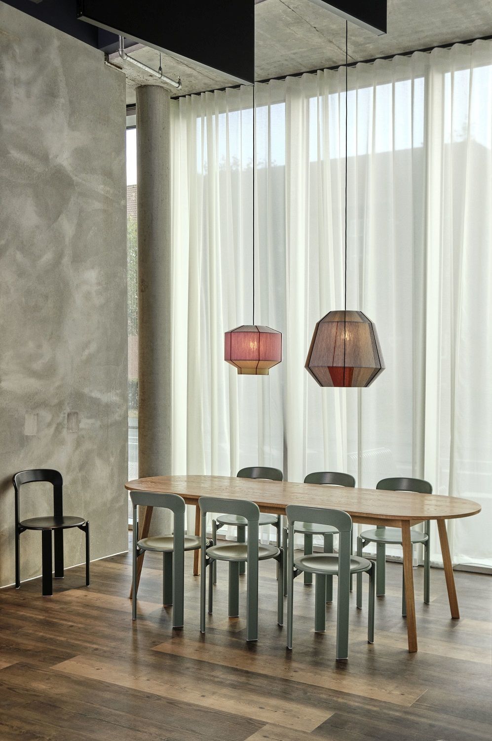 Heller Raum mit Triangle Leg Table Esstisch von Hay, umgeben von grünen Stühlen und Pendelleuchten.