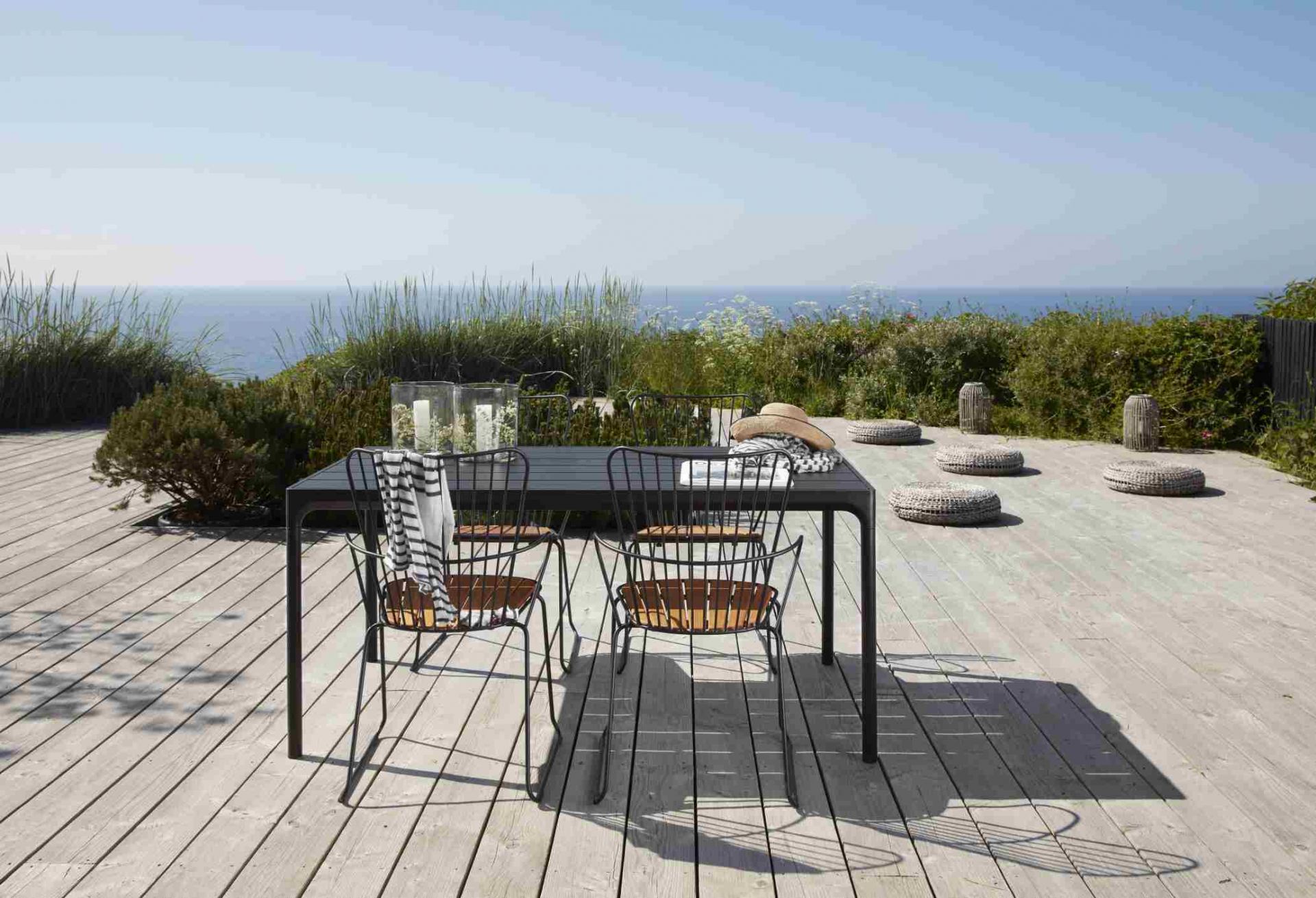 Houe Esstisch "Four" für den Außenbereich mit Stühlen auf einer Holzterrasse.