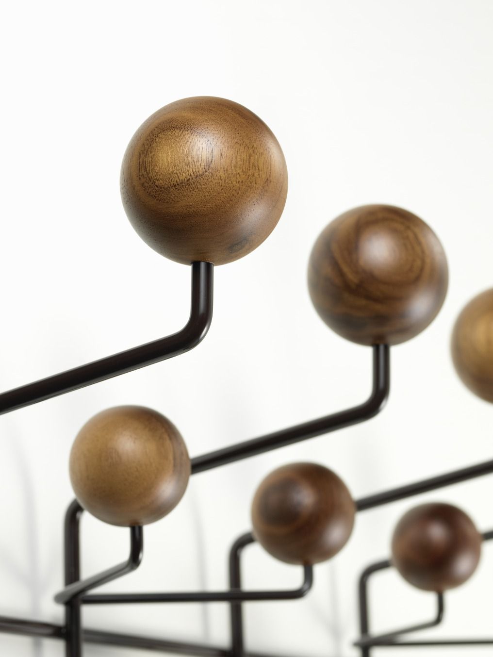 Detailaufnahme der Eames Hang it all Garderobe von Vitra mit bunten Holzkugeln in Nussbaum.