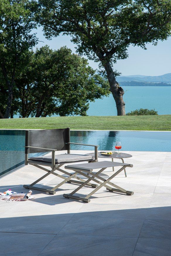 Terra Lounge Chair Sessel von Emu mit Fußhocker und Beistelltisch am Pool im Freien.