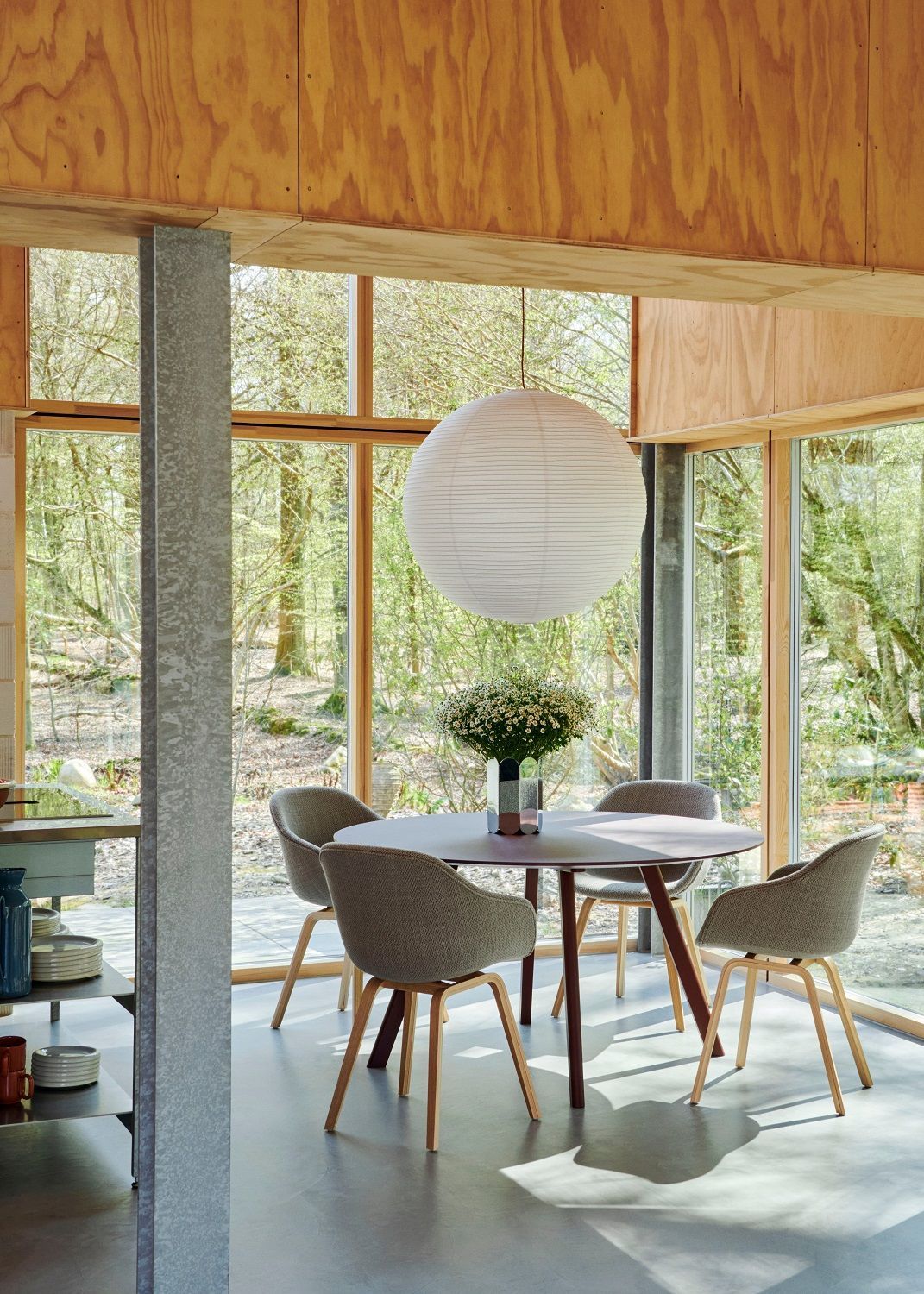 Esszimmer mit rundem Tisch und vier grauen About a Chair AAC223 Stühlen von Hay.