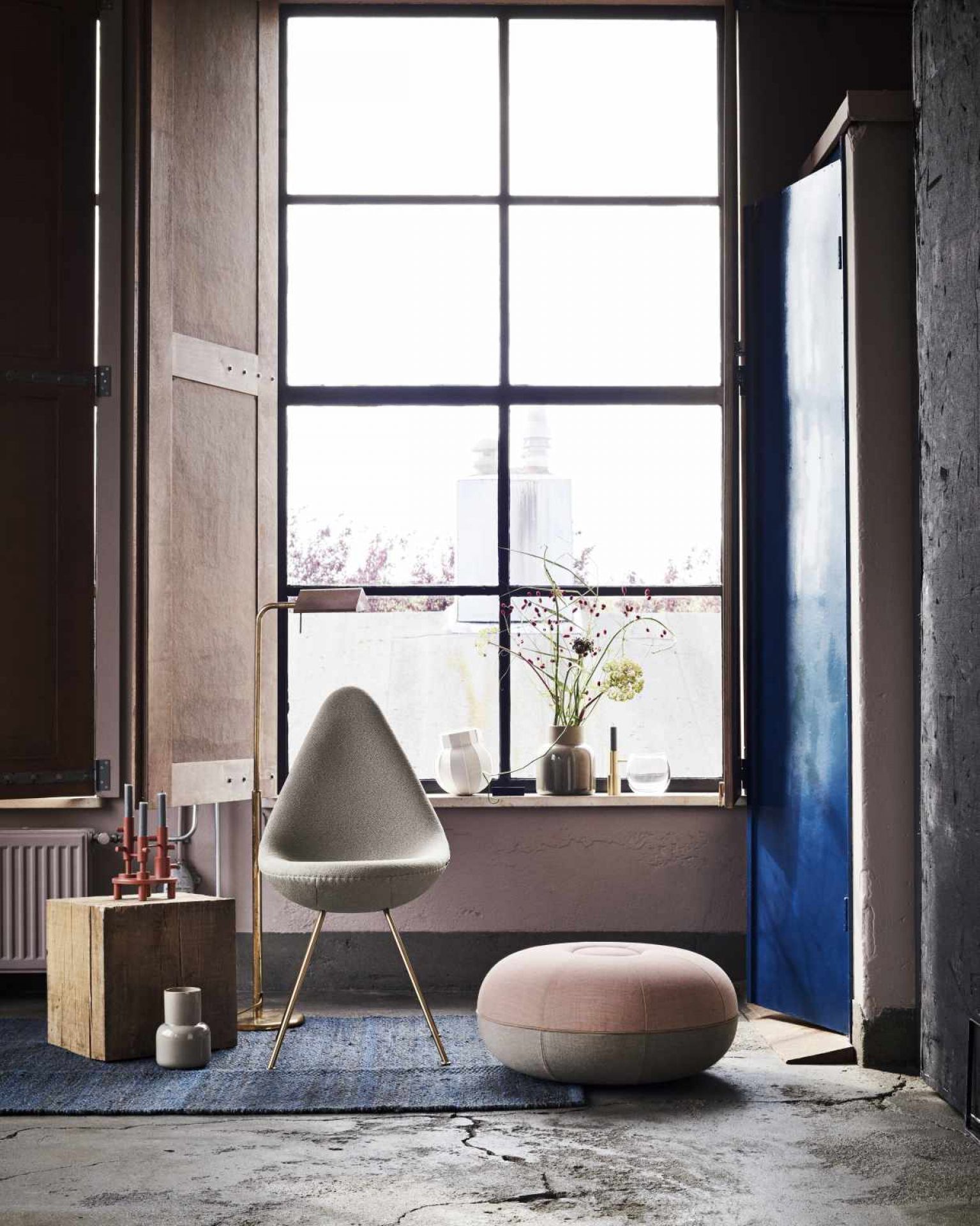 Grauer Drop Stuhl von Fritz Hansen mit goldenen Beinen in modernem Interieur mit Fenster und Dekoration.