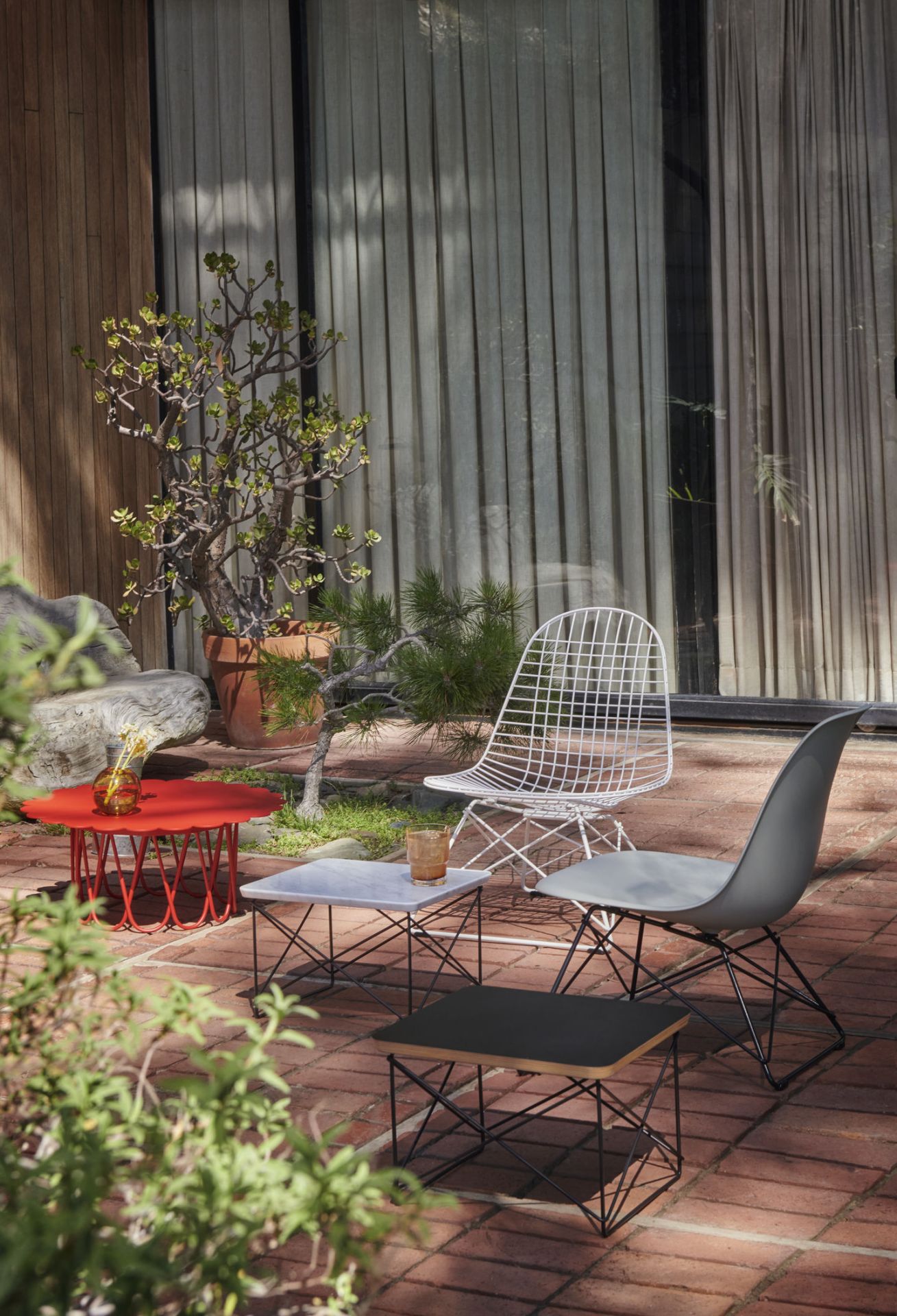 Vitra LKR-2 Wire Chair Stuhl mit Sitzbezug und verschiedene Design Beistelltische im Garten.