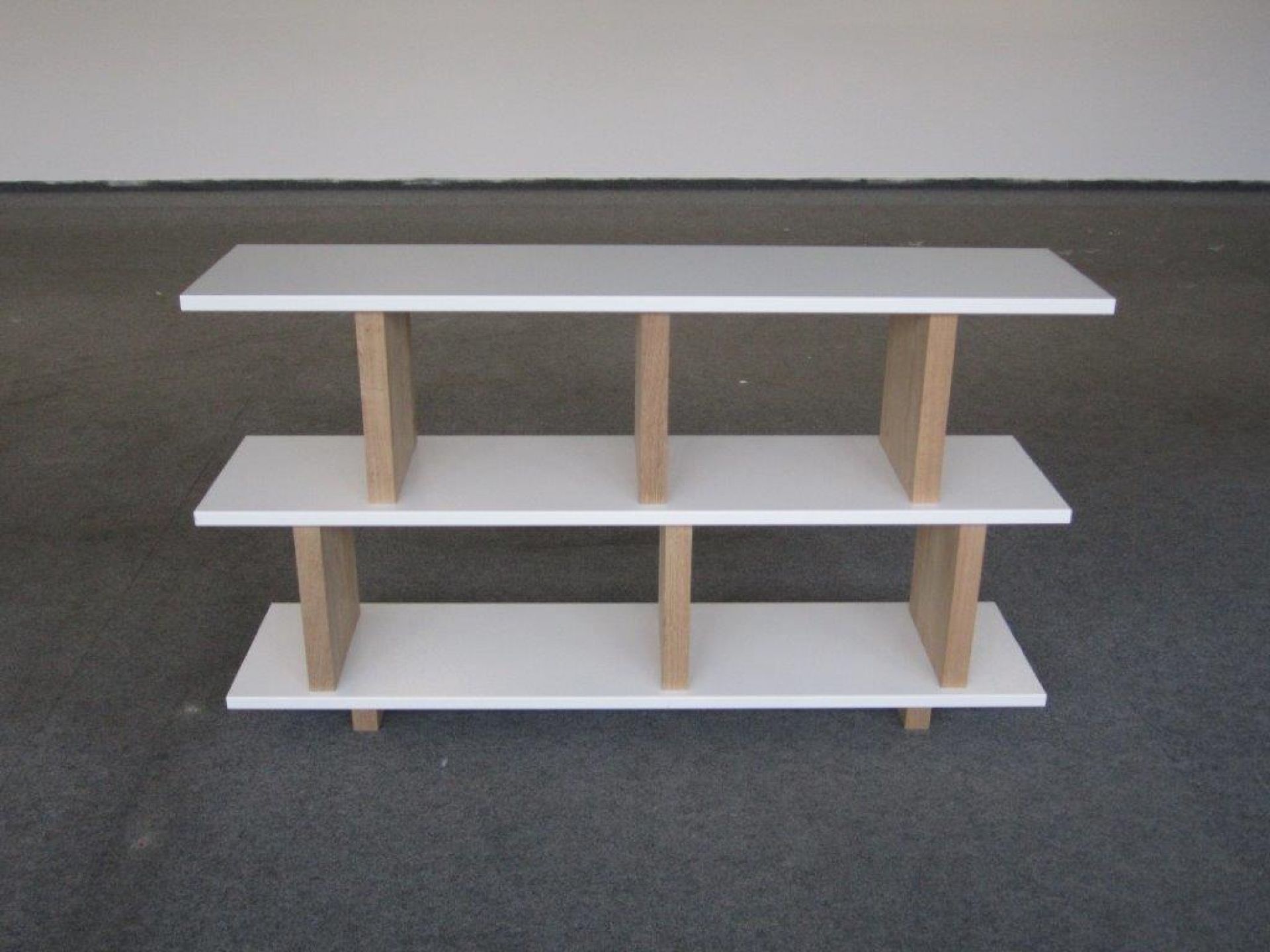 Tojo Regal: Weißes Anbaumodul mit drei Ebenen und Holzstreben für Wohnzimmer oder Büro.