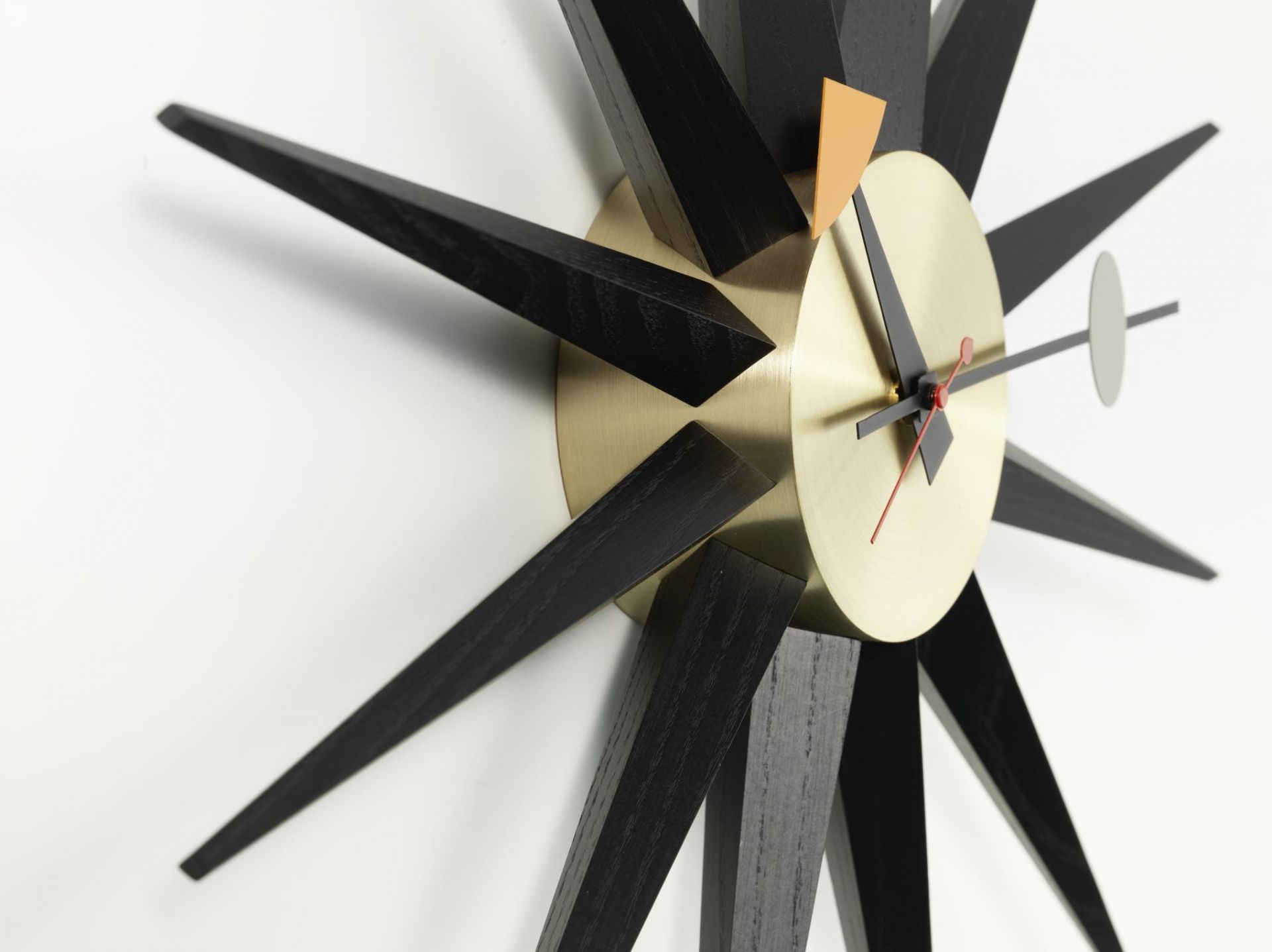 Sunburst Clock: Schwarze Wanduhr im Retro Design mit Messing Ziffernblatt von Vitra.