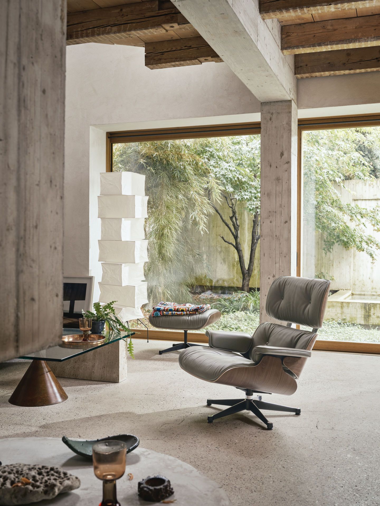 Eames Lounge Chair von Vitra in grauem Leder und Holzfurnier in modernem Wohnzimmer.