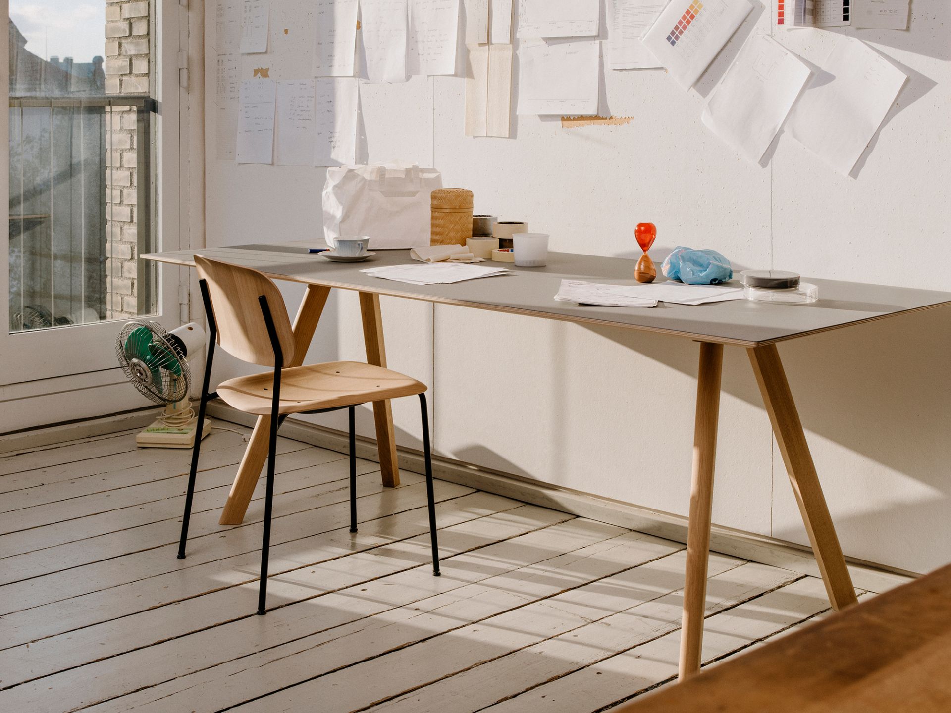 Hay Copenhague CPH 30 Tisch mit grauem Linoleum und Holzbeinen in einem hellen, modernen Arbeitszimmer.