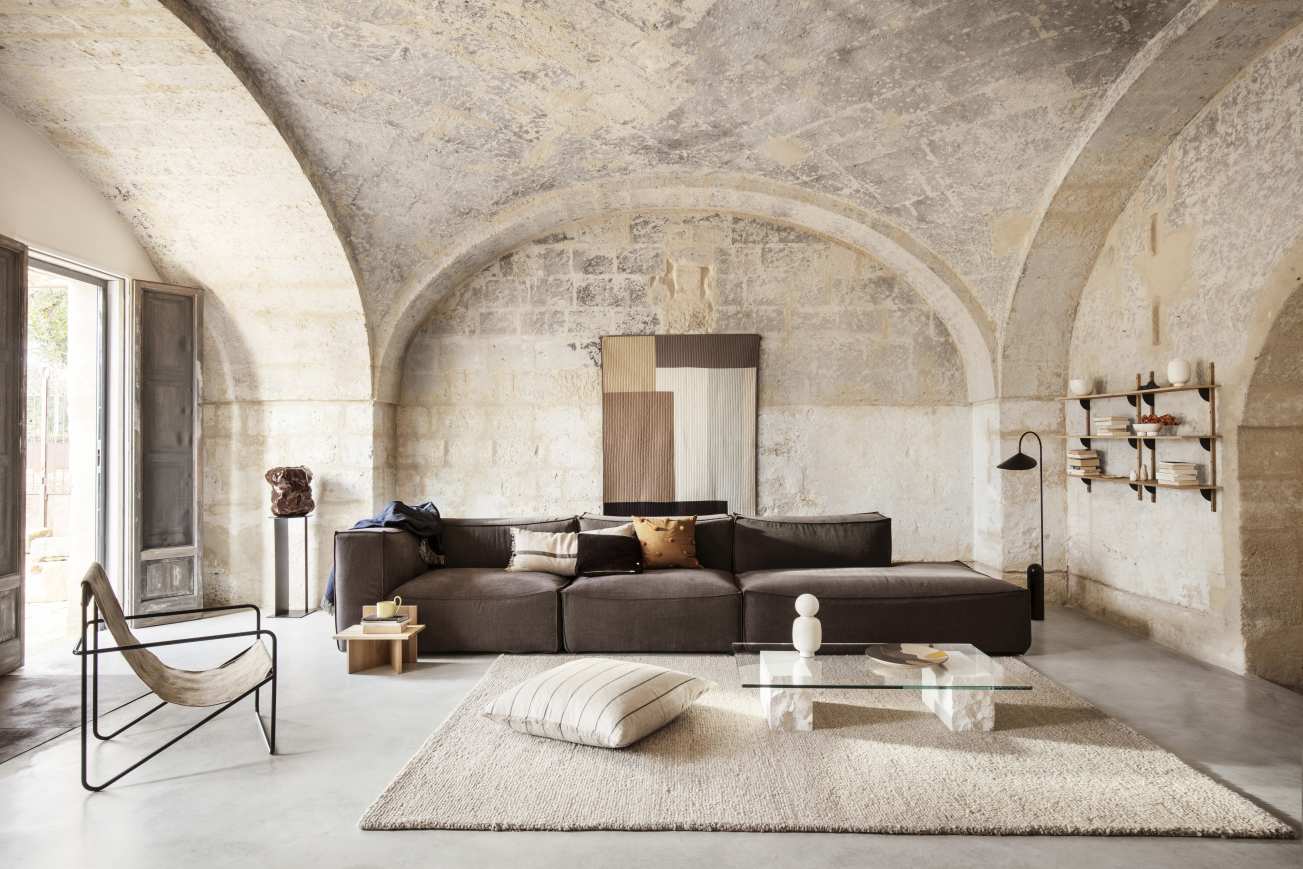 Wohnzimmer Interieur mit braunem Modulsofa, Teppich und Ferm Living Mineral Coffee Table Bianco Curia.