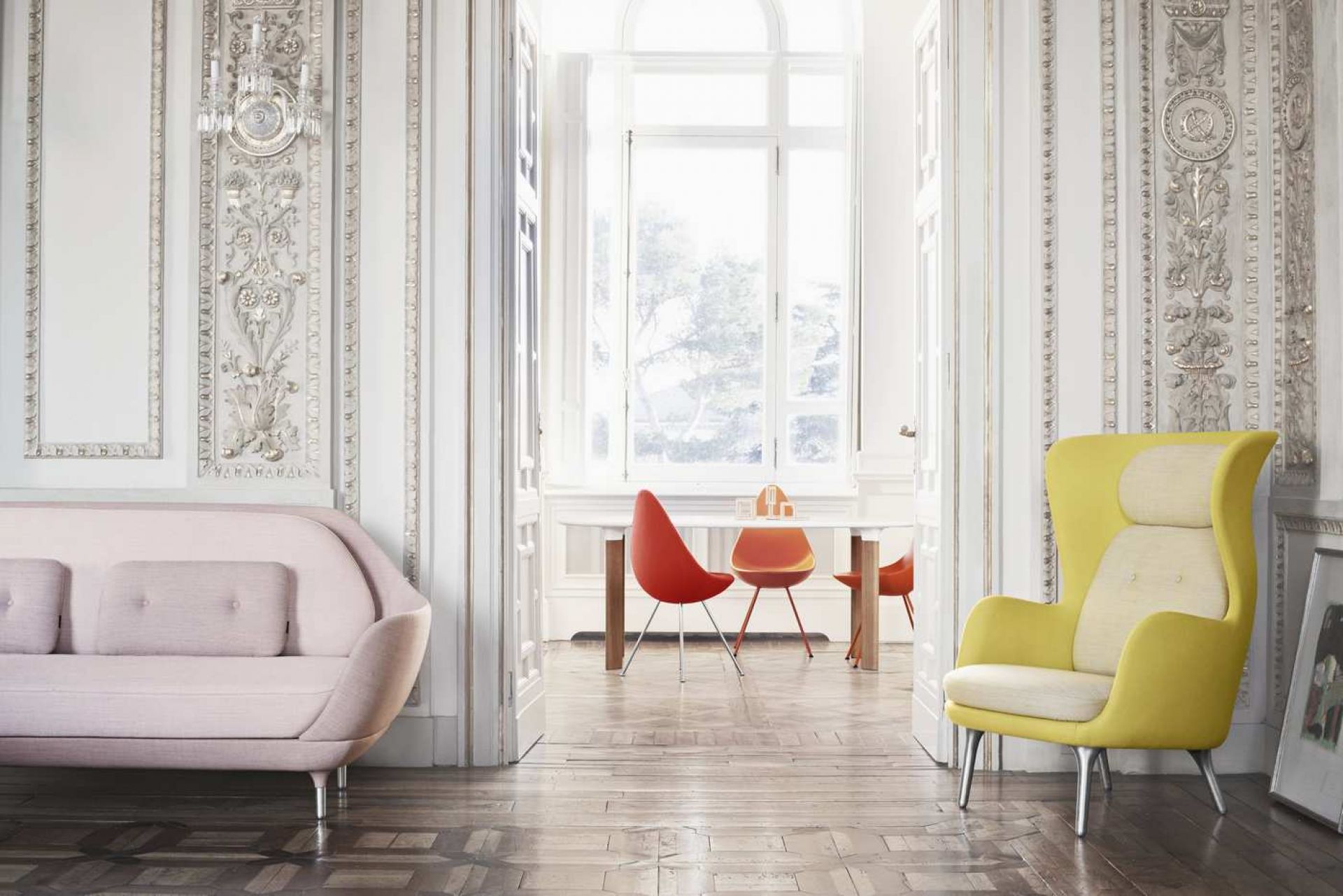 Helles Interieur mit Analog Tisch von Fritz Hansen, Sofa in Rosa und gelbem Sessel.