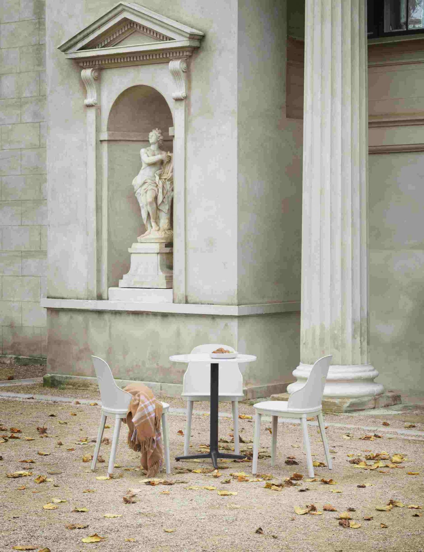 Drei Allez Chair PP Stühle von Normann Copenhagen und ein Tisch im Außenbereich vor historischer Kulisse.