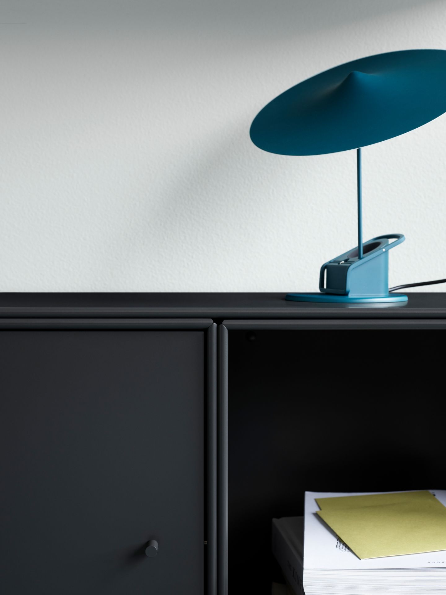 Detailaufnahme: Graues Montana Mini Modul mit Tür und blauer Lampe. Stauraum für Wohnzimmer.