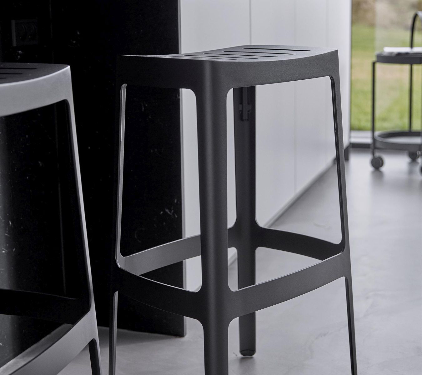 Schwarzer Cut Barhocker von Cane-Line, stapelbar, mit schlichtem Design für Küche oder Bar.
