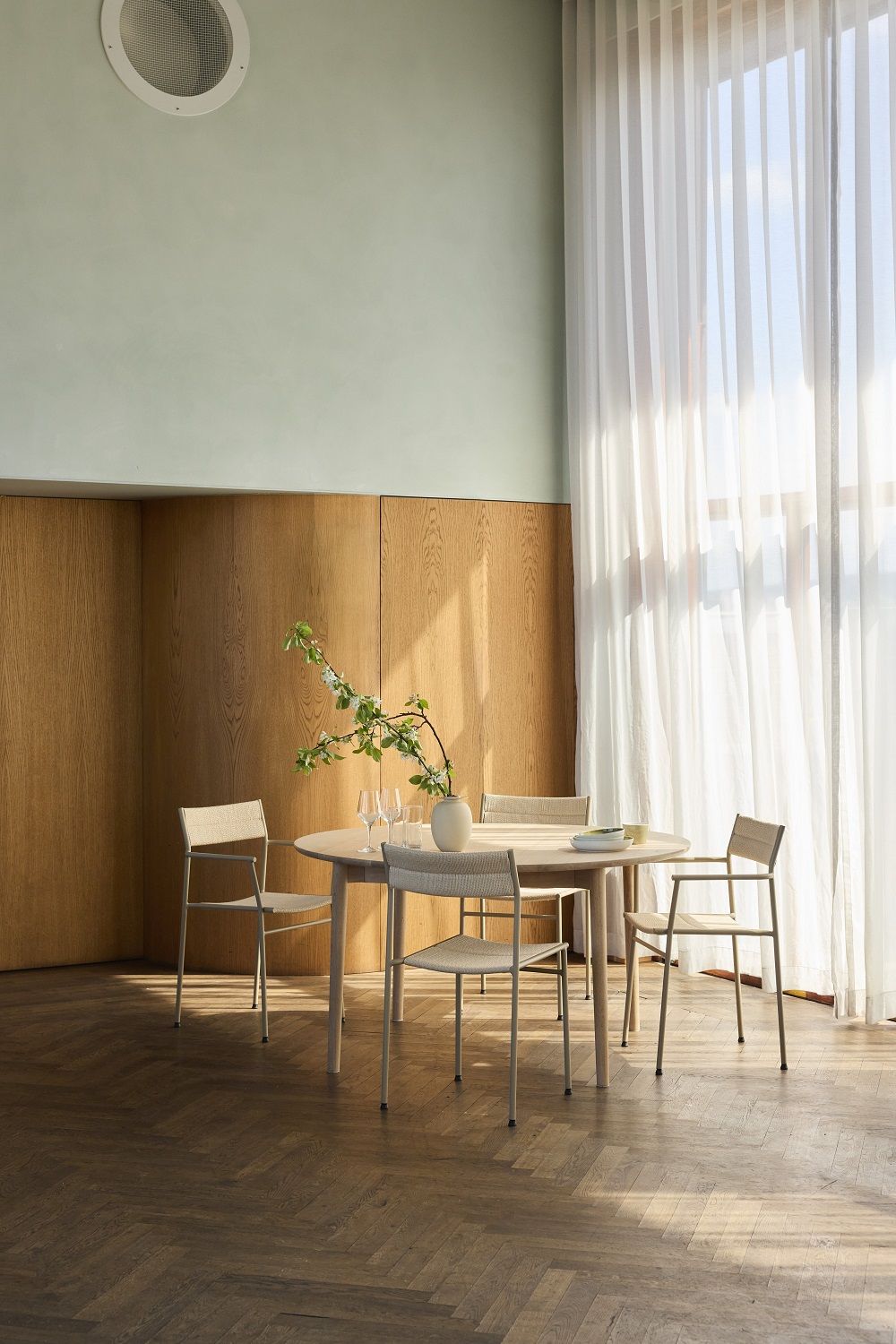 Vier Vev Dining Stühle von Northern um einen runden Esstisch in einem hellen Raum.