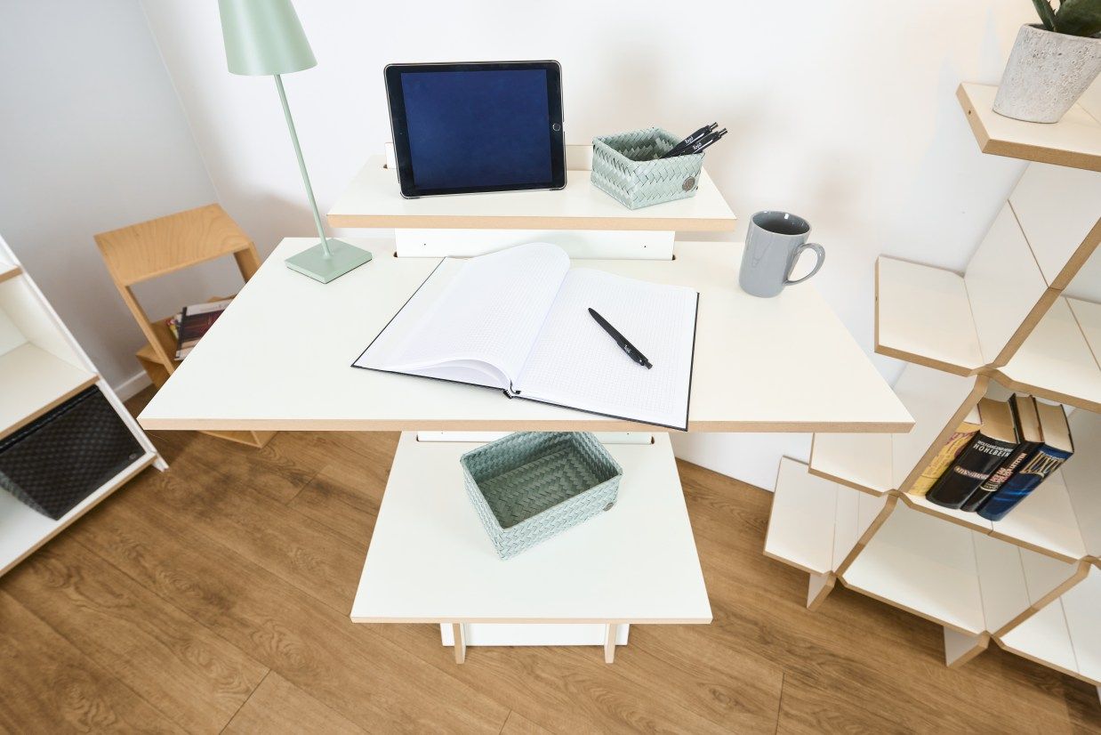 Tojo Stehpult aus Holz, höhenverstellbar, mit Tablet, Notizbuch, Stift und Lampe auf dem Schreibtisch.