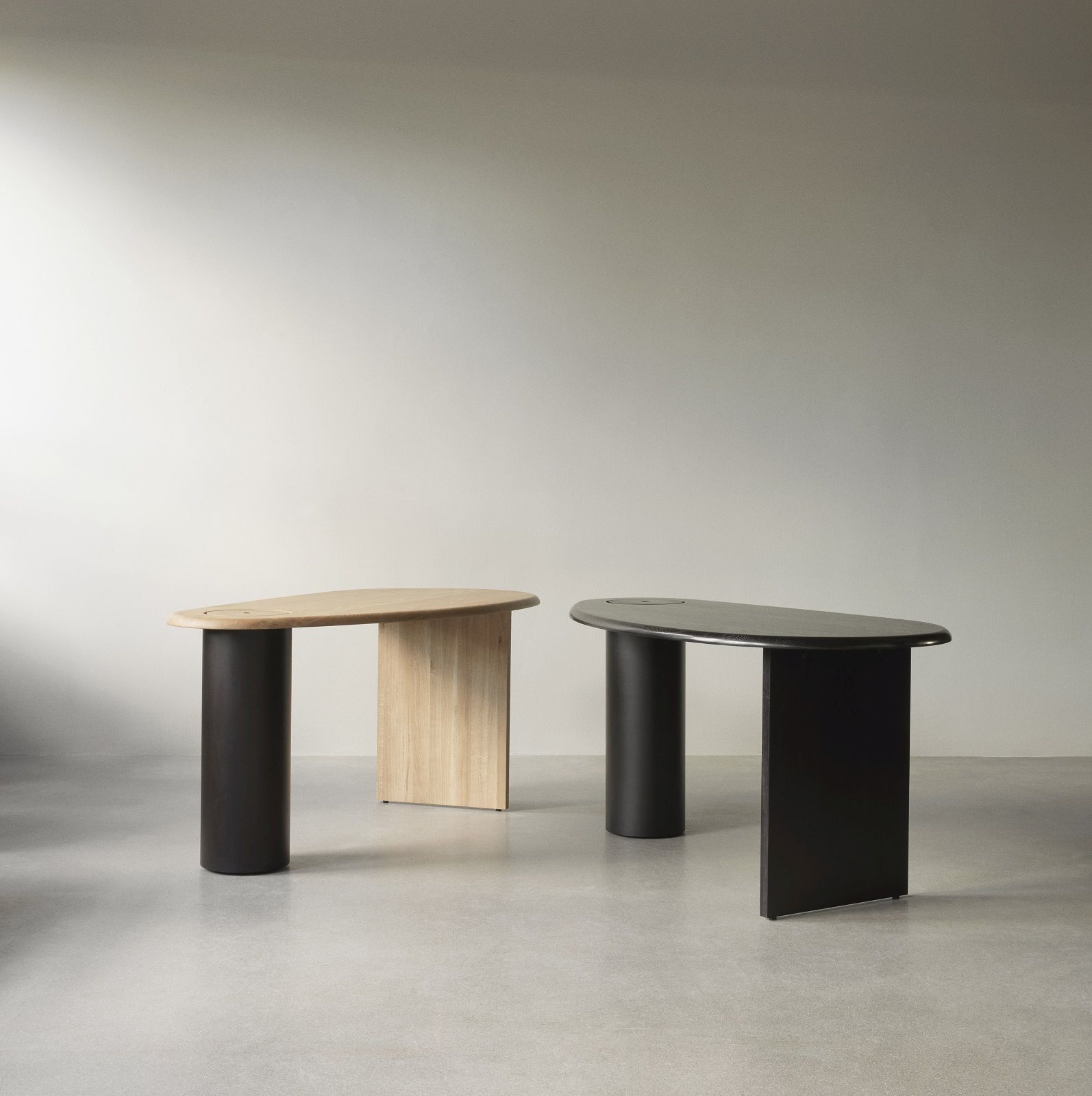 Audo Copenhagen Eclipse Desk Schreibtische in Eiche hell und Schwarz vor hellem Hintergrund.