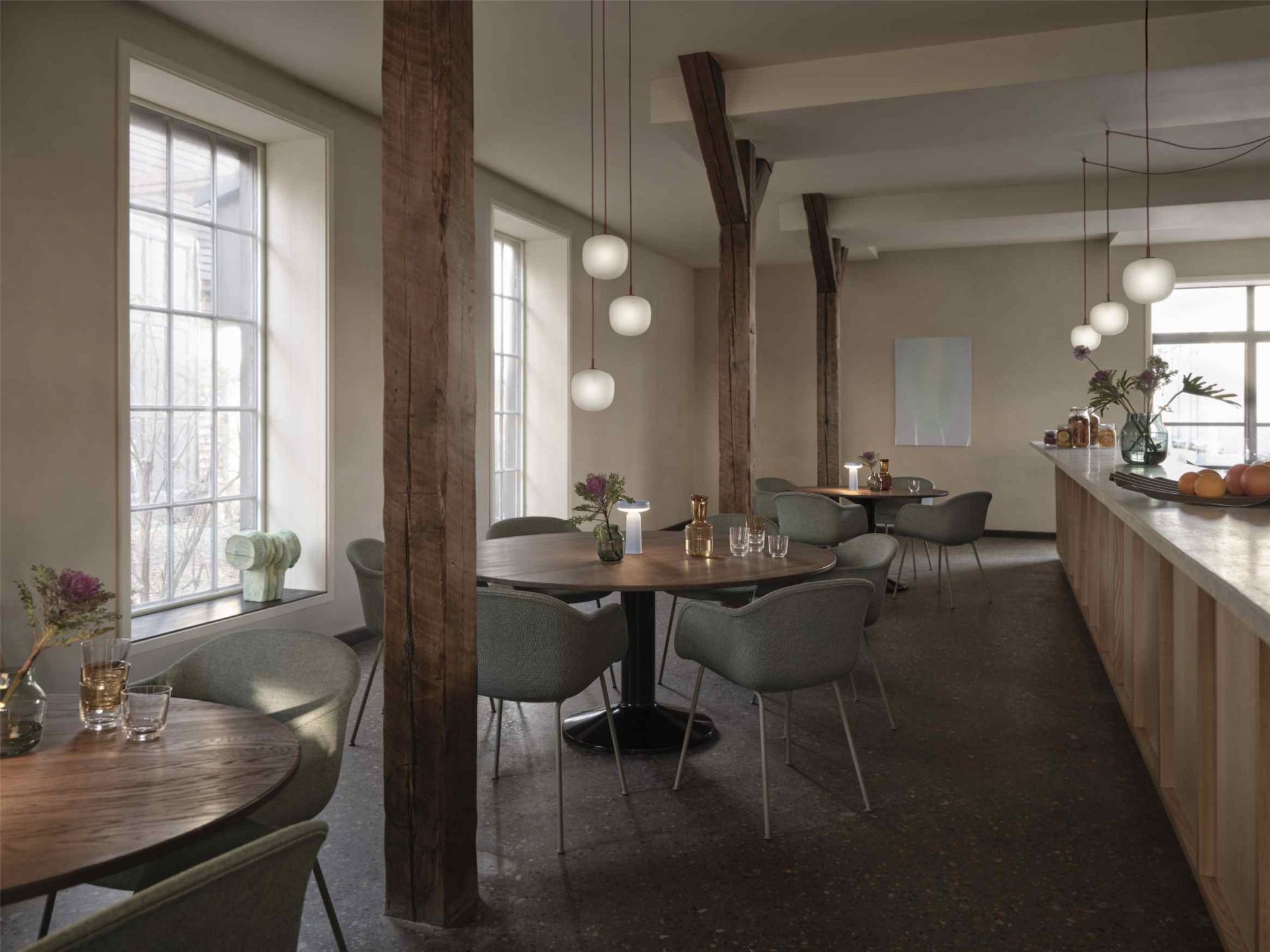 Innenaufnahme eines Restaurants mit dem runden Muuto MIDST Table Esstisch und grauen Stühlen.