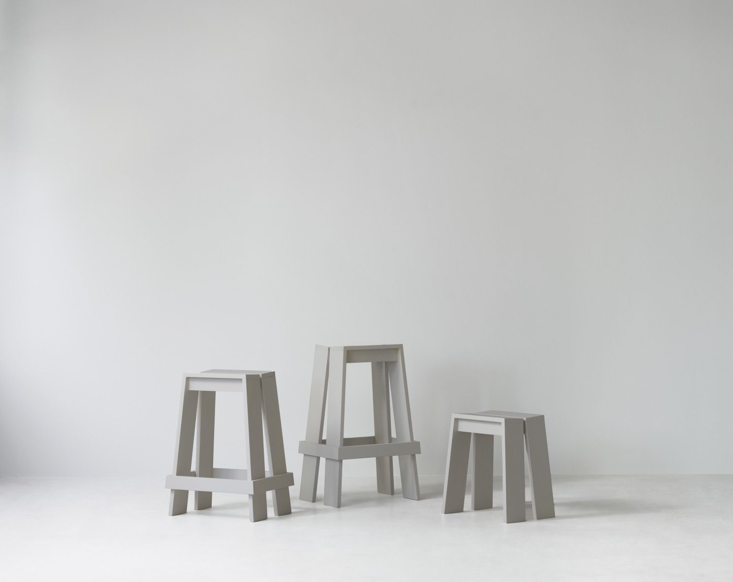 Drei graue Barhocker "Let Barstool H 65 cm" von Normann Copenhagen vor weißem Hintergrund.