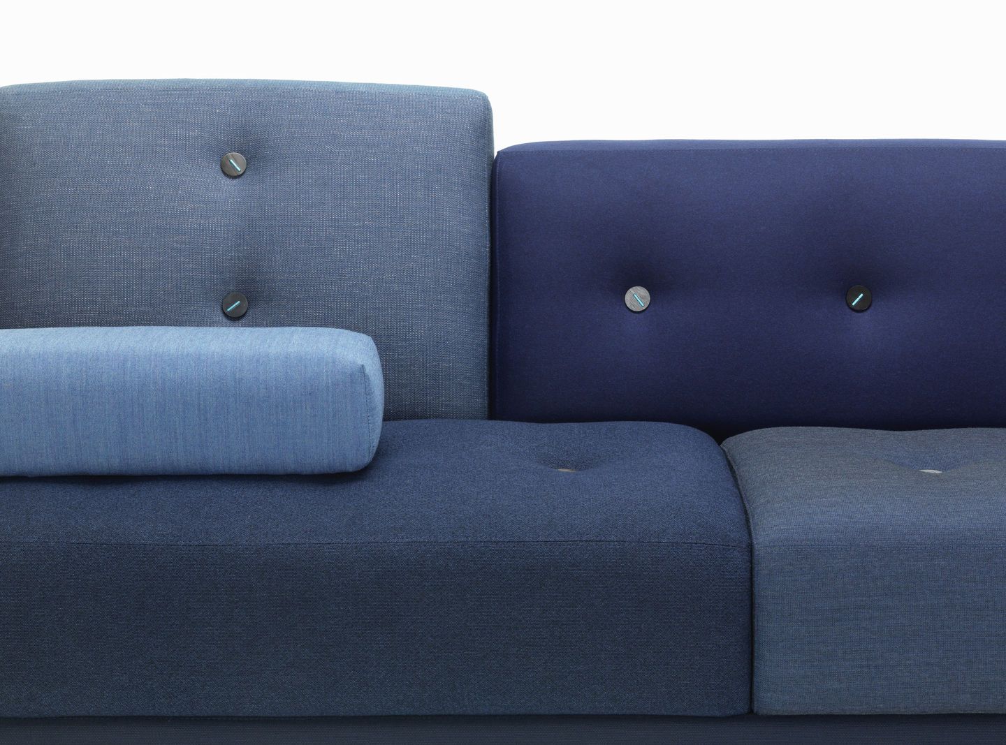 Detailaufnahme vom blauen Vitra Polder Sofa mit Knopfdetails und Zierkissen, modernes modulares Design.