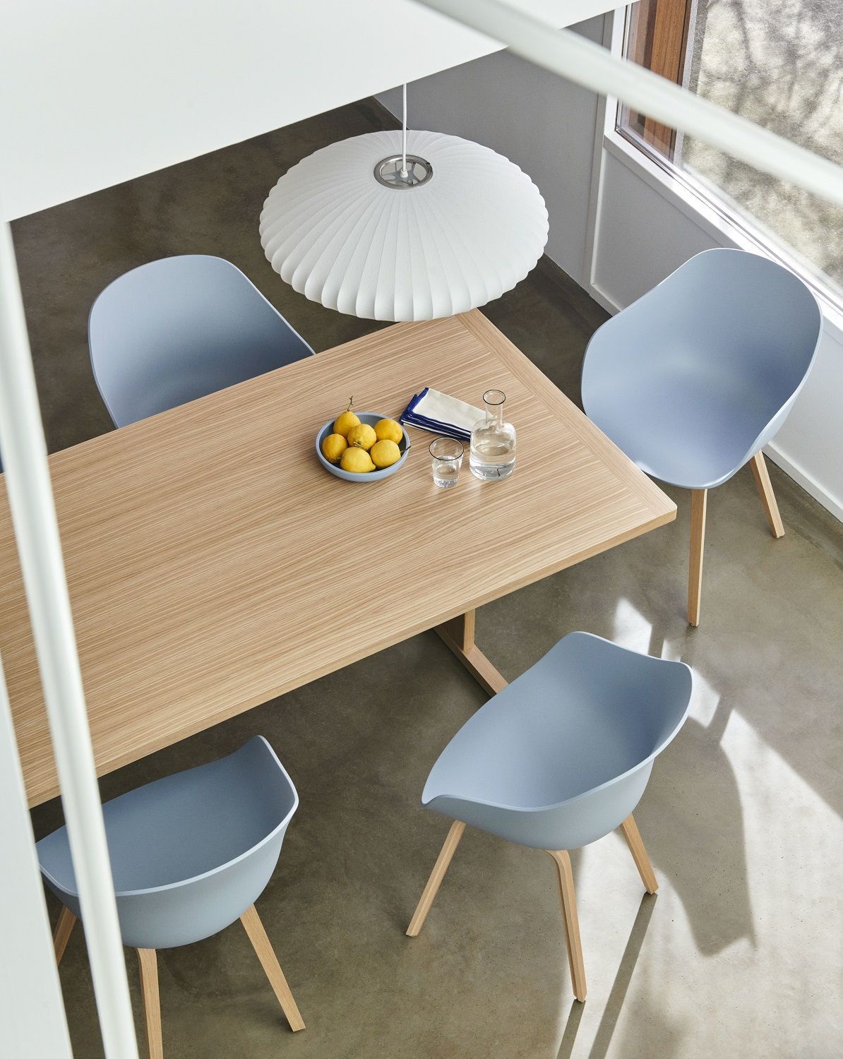 Esstisch mit vier hellblauen Hay About a Chair AAC222 Stühlen und Zitronen in einer Schale.