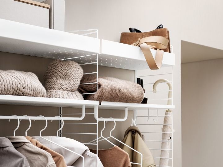 Flur String Möbel: Weißes Regalsystem mit Kleidung, Accessoires und Dekoration für eine stilvolle Flurgestaltung.
