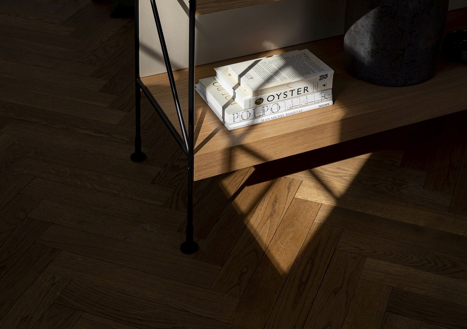 Detailaufnahme des Audo Copenhagen Zet Storage System Regals mit Büchern auf einem Holzboden.
