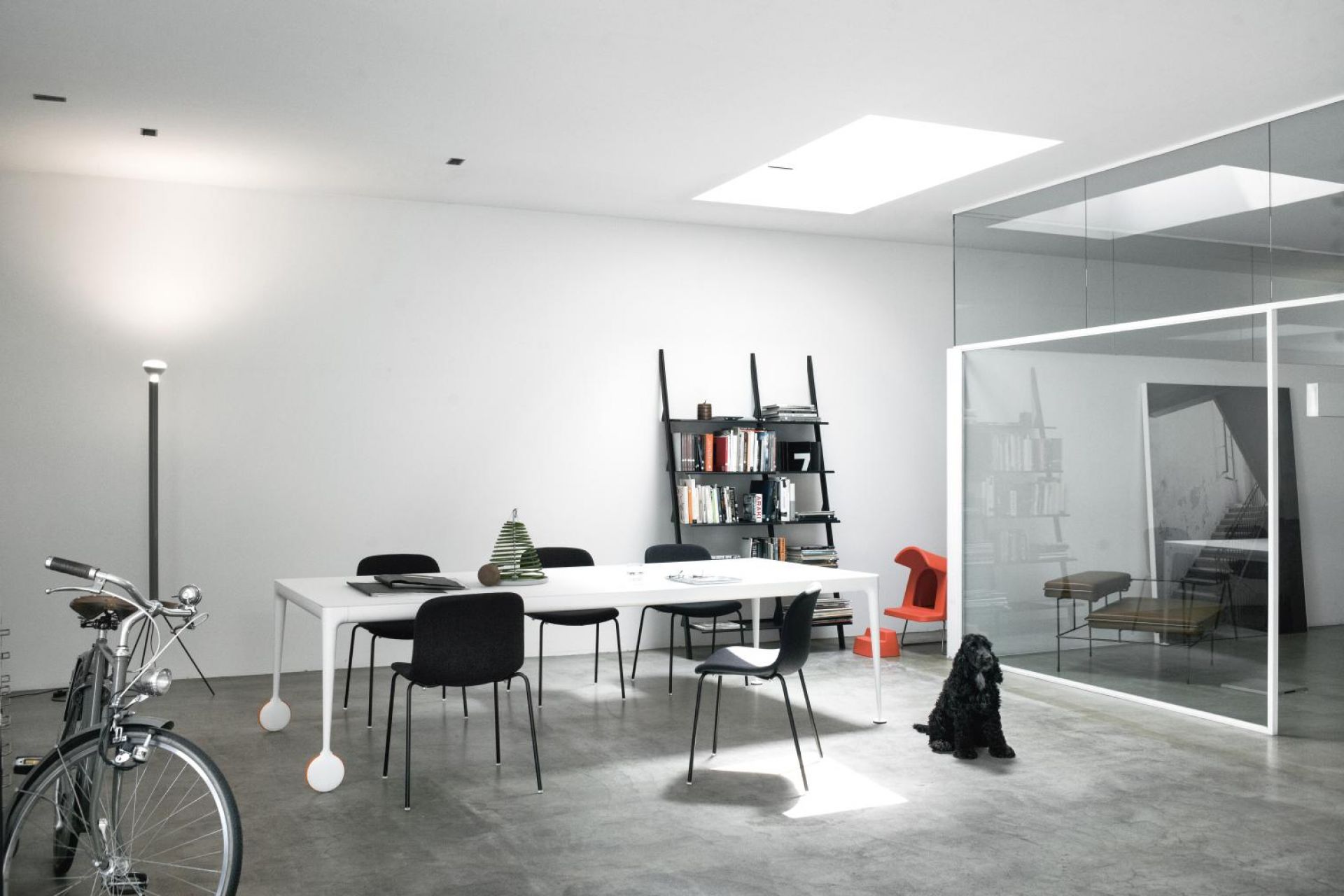 Heller Raum mit Big Will Table von Magis, rollbarer Tisch mit Stühlen und Bücherregal.