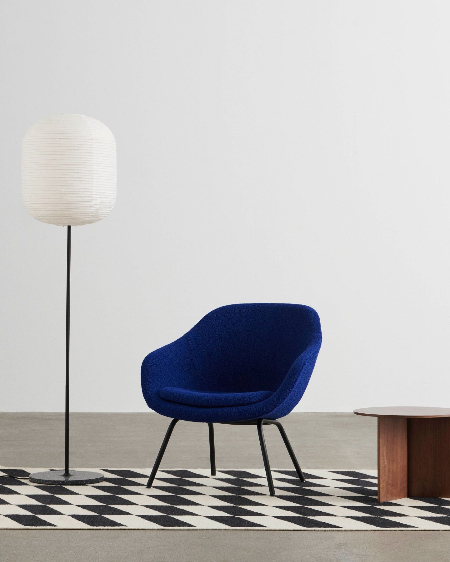 Blauer About a Lounge AAL 87 Sessel von Hay mit Lampe und Tisch auf Teppich.