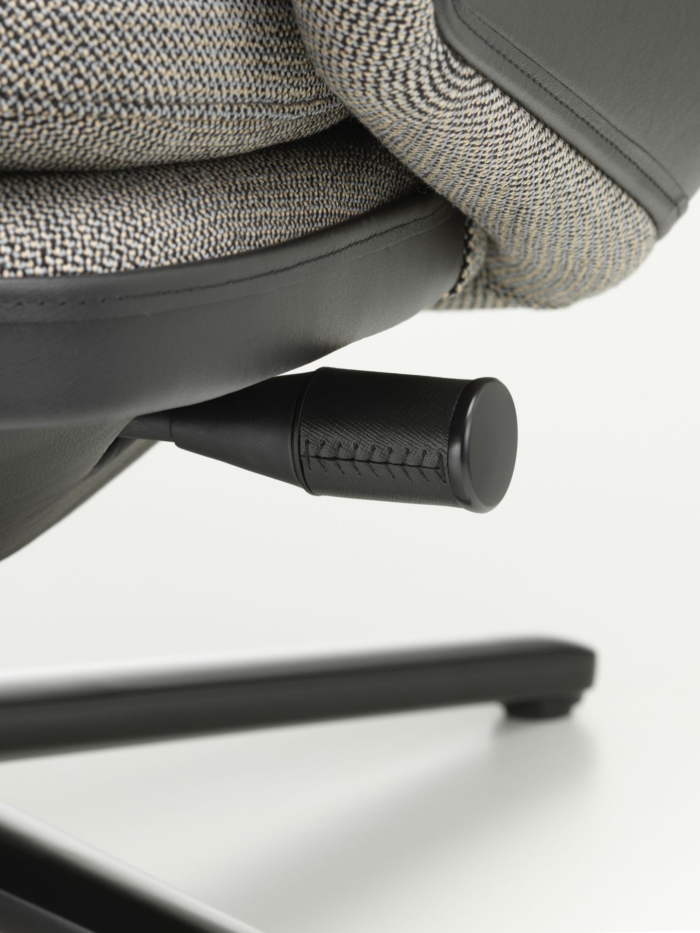 Detailaufnahme des Vitra Grand Relax Sessels: Verstellmechanismus, Stoffbezug und Lederakzente des Designersessels.