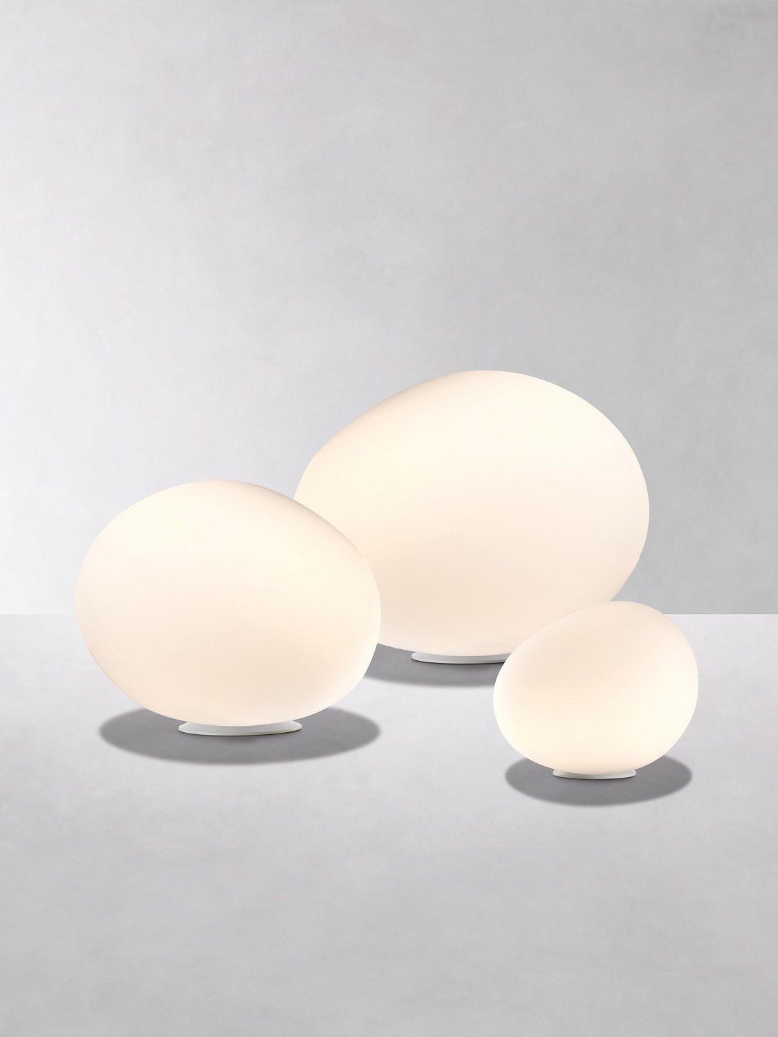 Drei weiße Poly Gregg Tischleuchten von Foscarini in verschiedenen Größen.