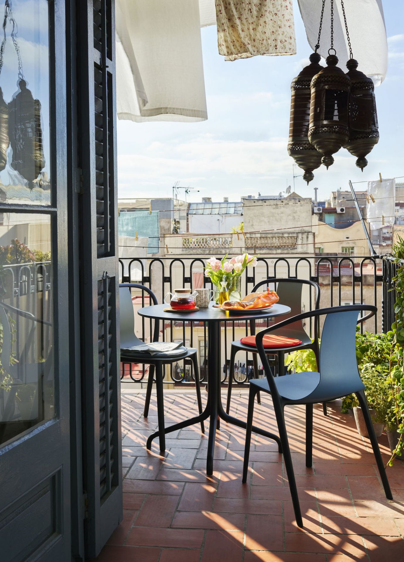 Belleville Armchair Plastic Stuhl von Vitra auf einem sonnigen Balkon mit Tisch und Frühstück.