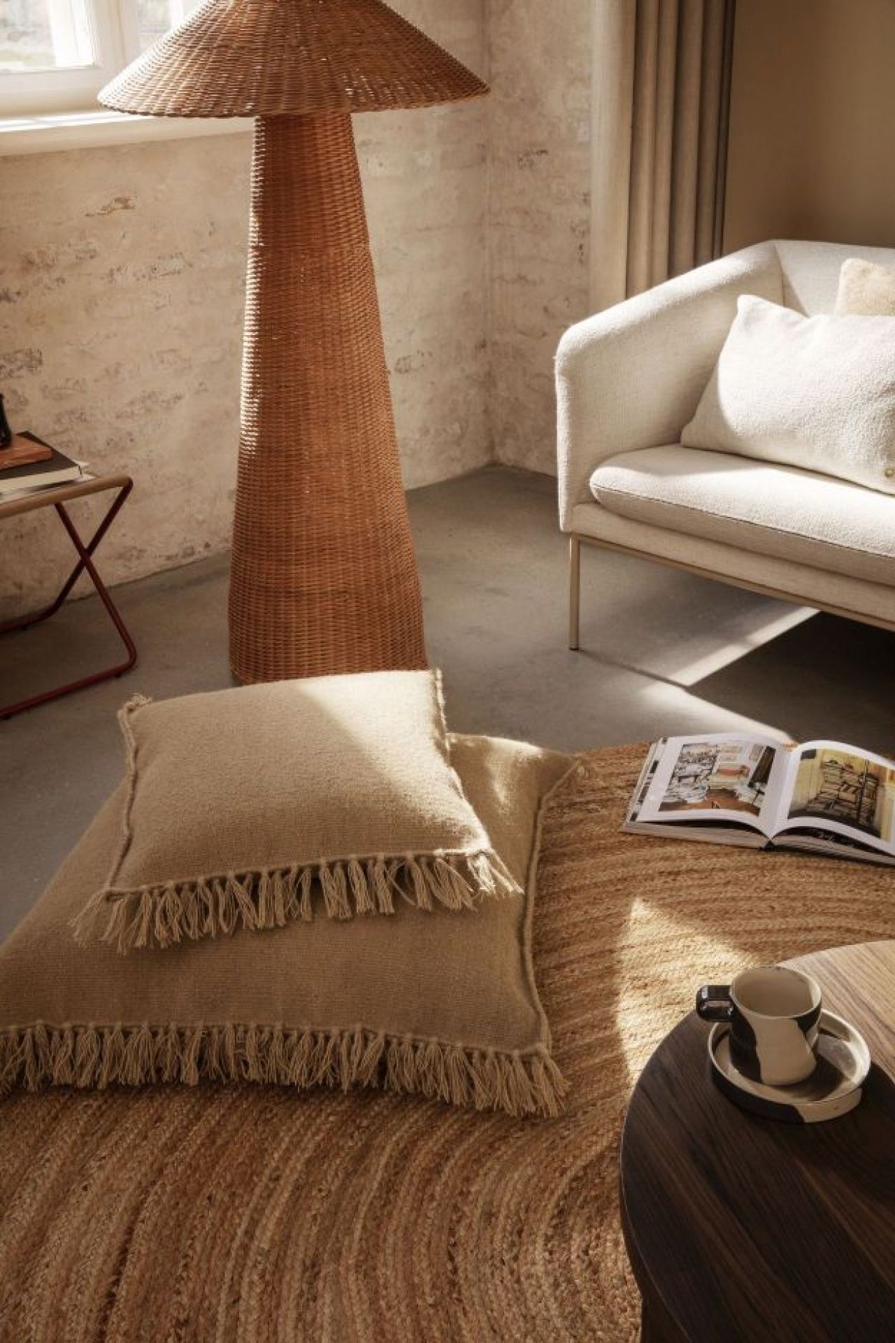 Dou Floor Lamp Stehlampe von Ferm Living aus Rattan im Wohnzimmer mit Kissen.